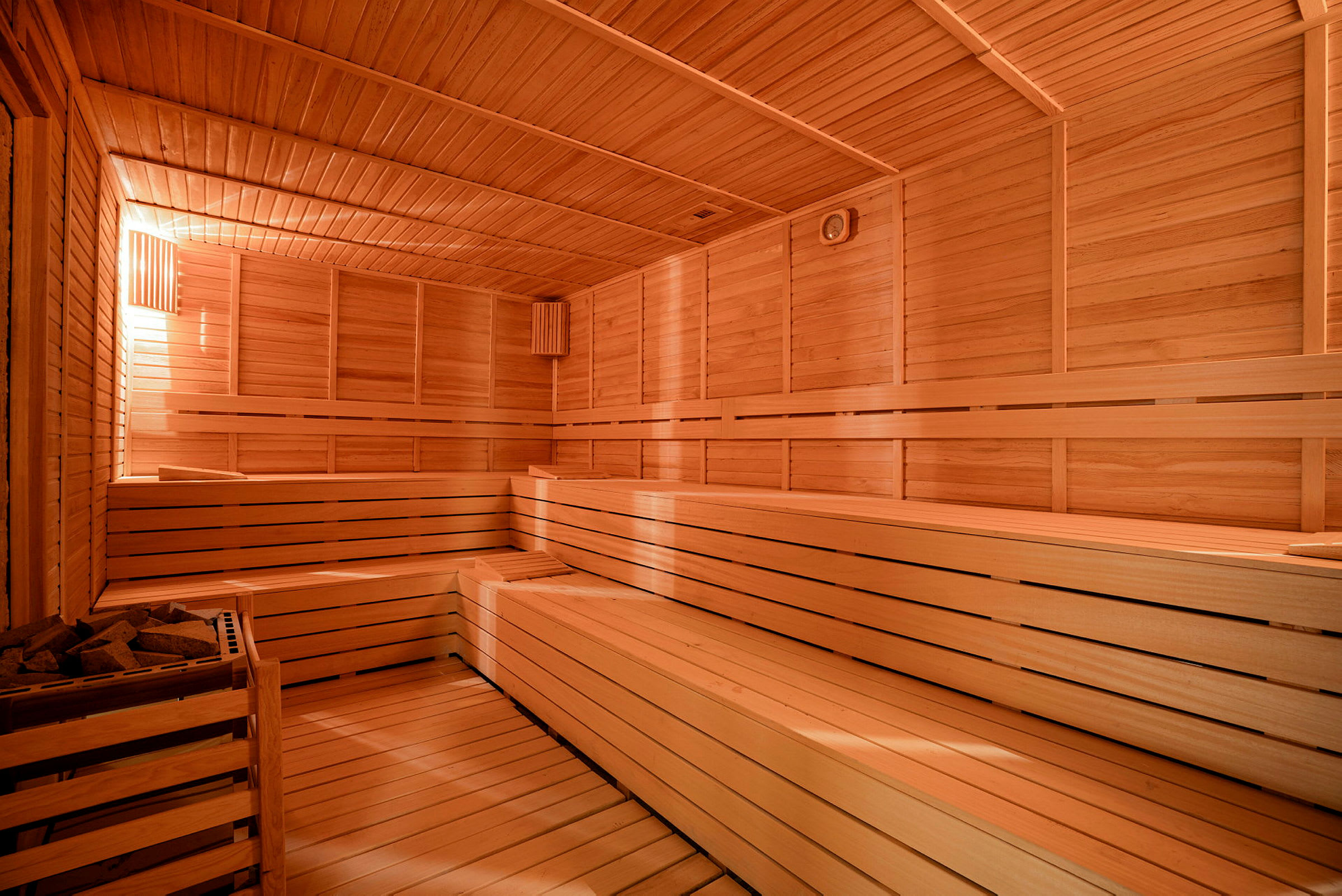 En træbeklædt sauna med bænke. (AI-genereret tekst)
