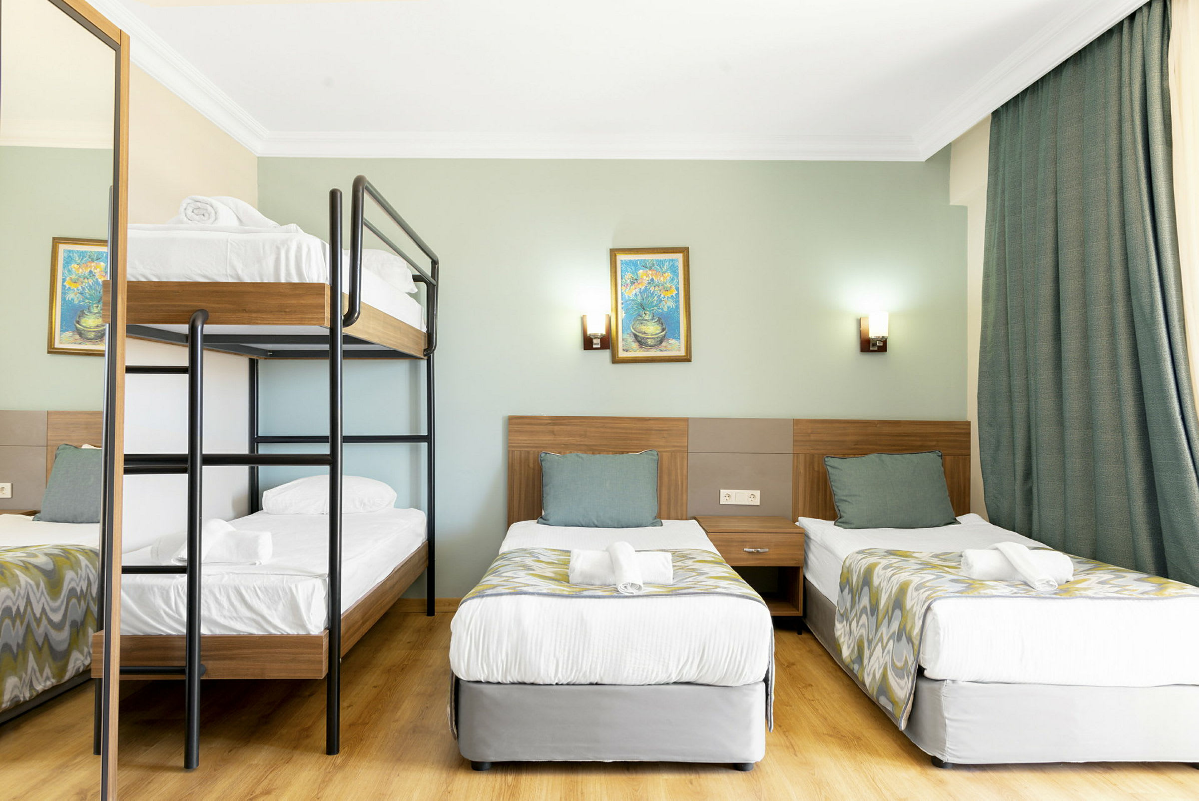 Hotelværelse med køjeseng og to enkeltsenge. (AI-genereret tekst)