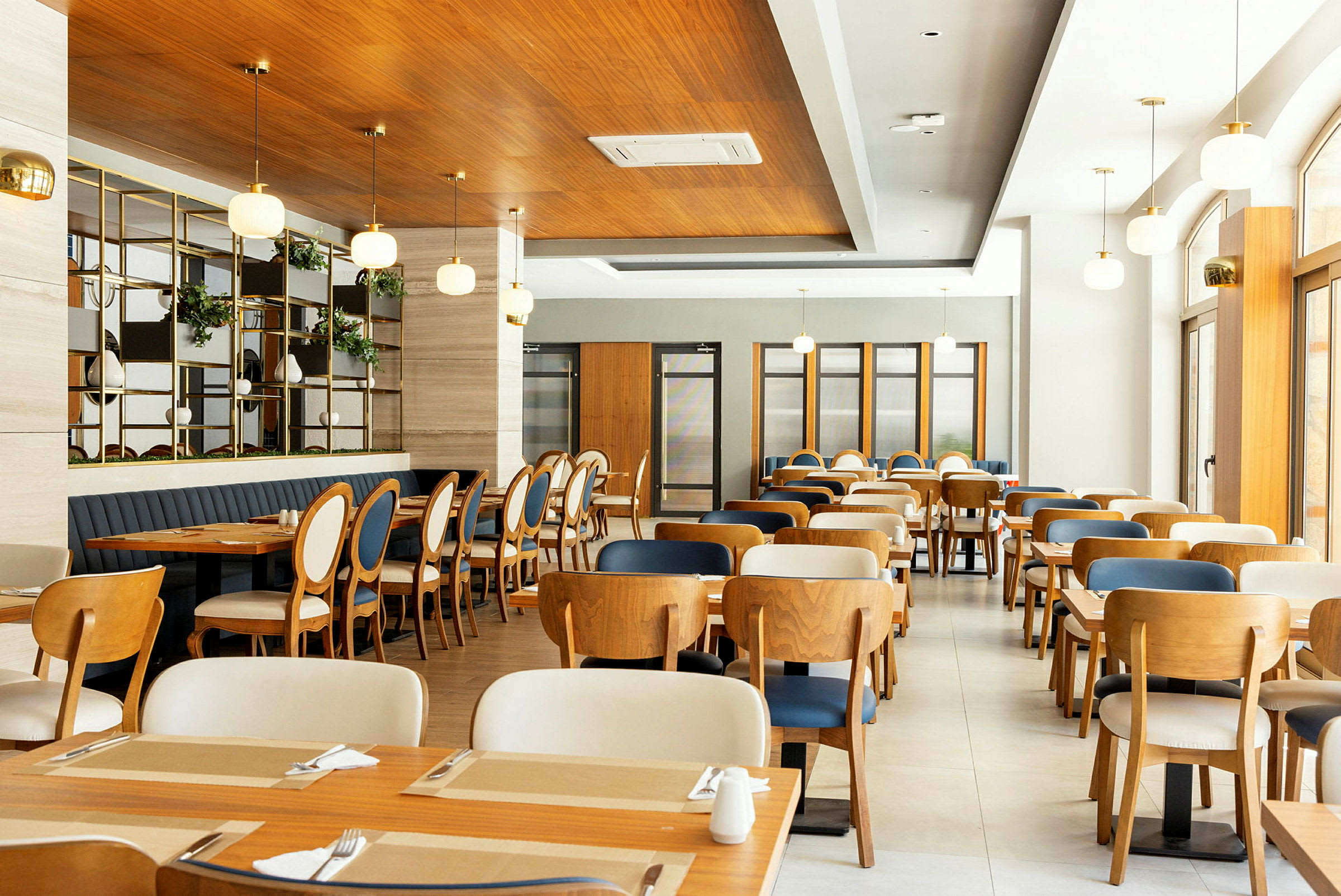 Interiør af en moderne restaurant med træborde og stole. (AI-genereret tekst)