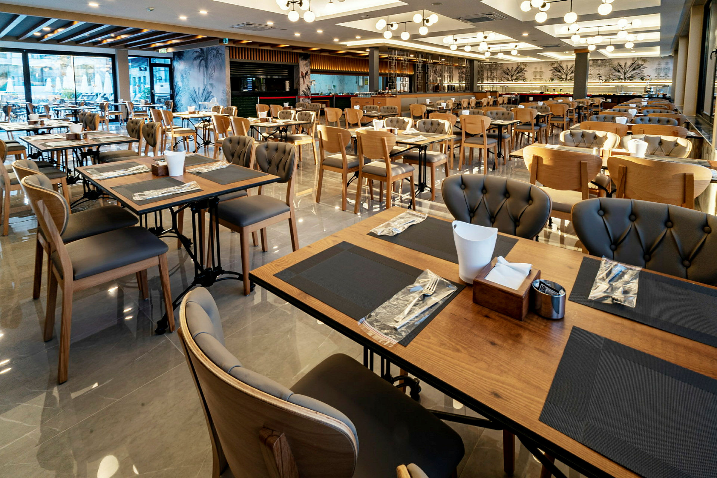 Billede af en restaurant med mange borde og stole, elegante borddekorationer og moderne belysning. (AI-genereret tekst)
