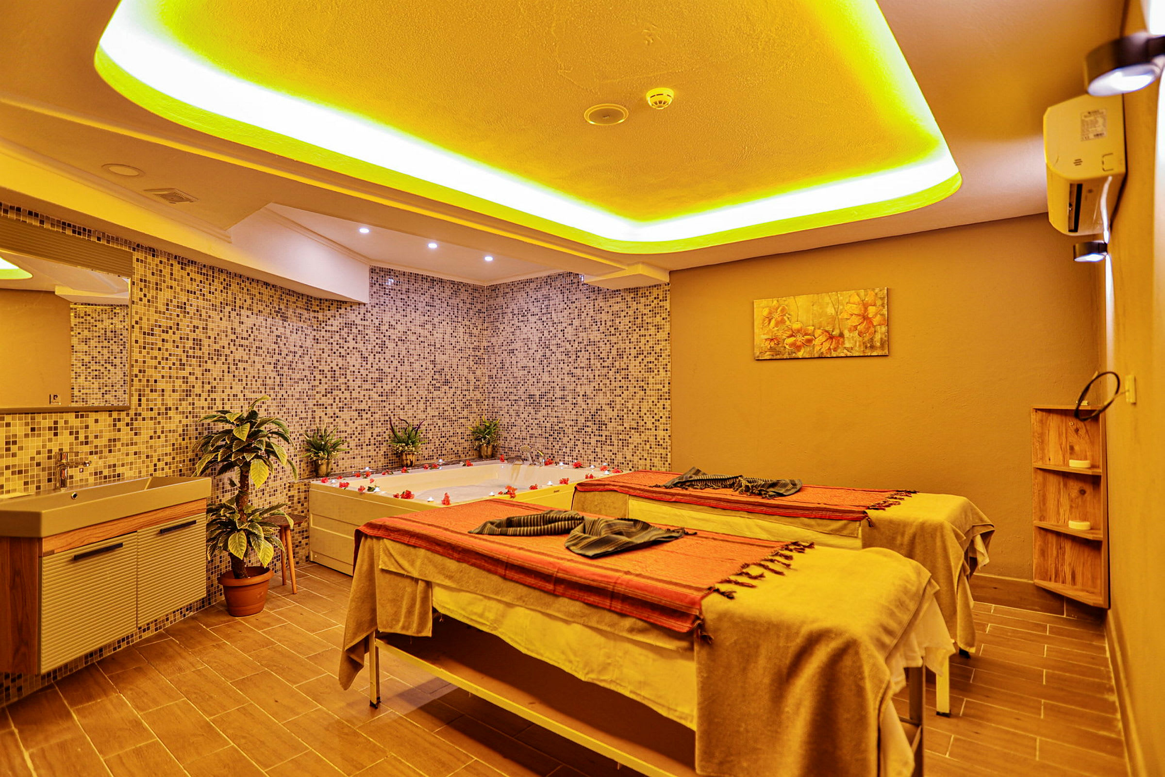 Et spa-rum med jacuzzi og massageborde. (AI-genereret tekst)