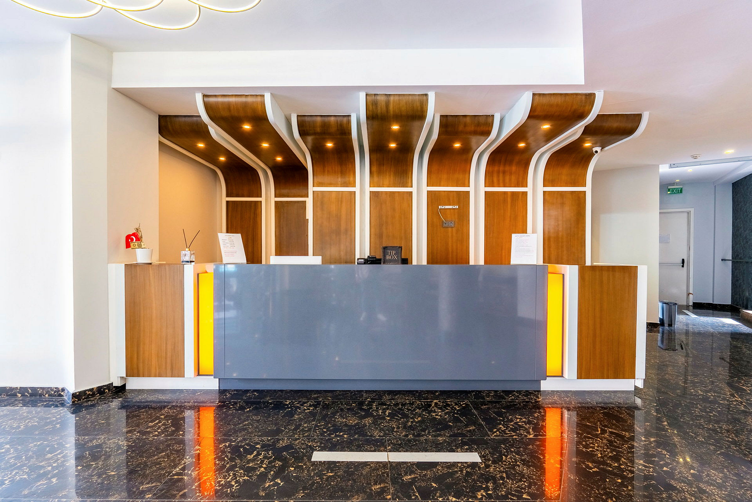 Hotelreception med moderne design, trædetaljer og marmorgulv. (AI-genereret tekst)