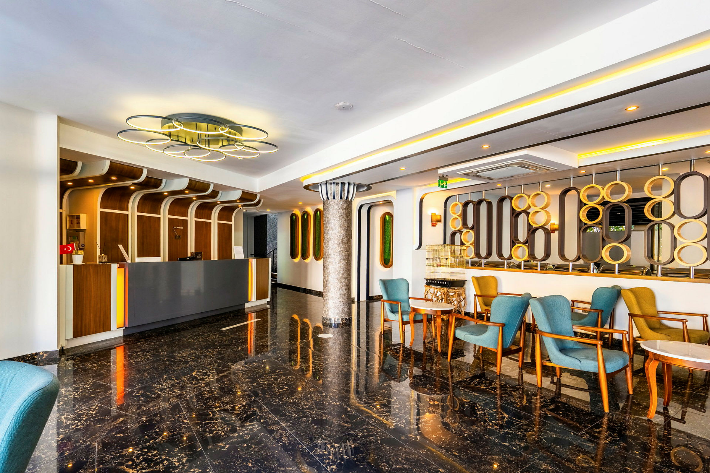Lobby med reception, blå og gule stole samt moderne indretning. (AI-genereret tekst)