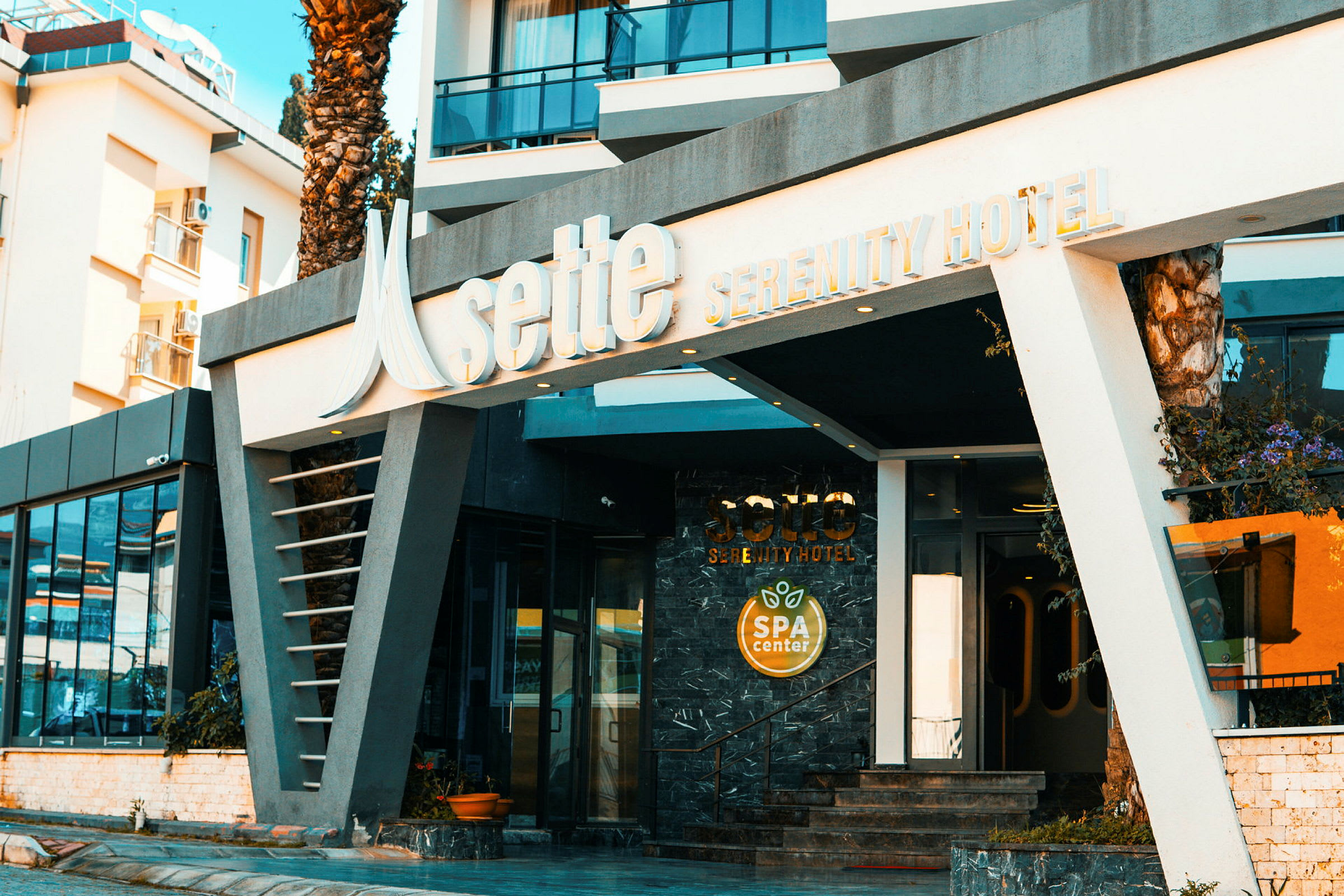 Indgangen til Sette Serenity Hotel med et skilt for spa-center. (AI-genereret tekst)
