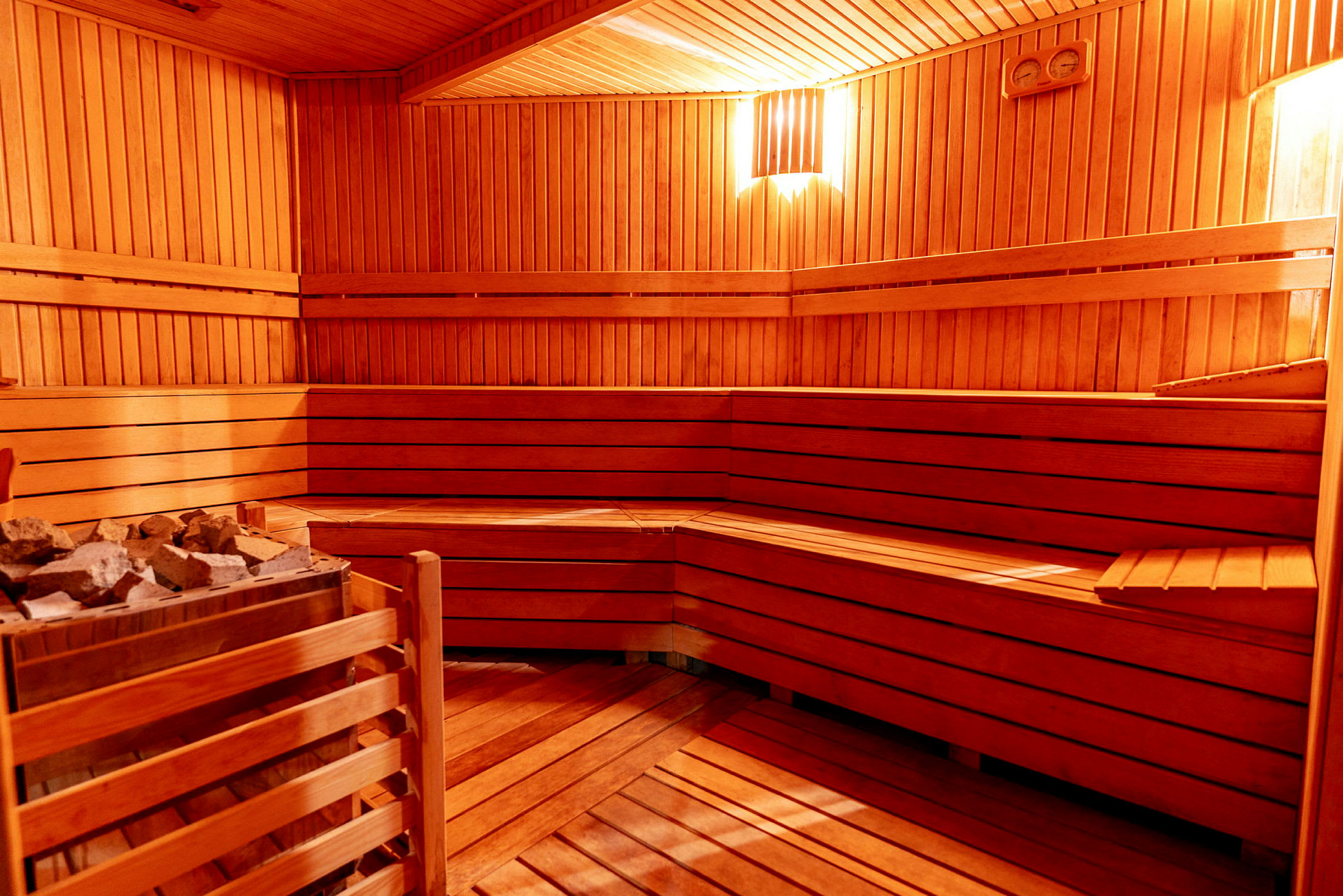 Inde i en træsauna med bænke og belysning. (AI-genereret tekst)