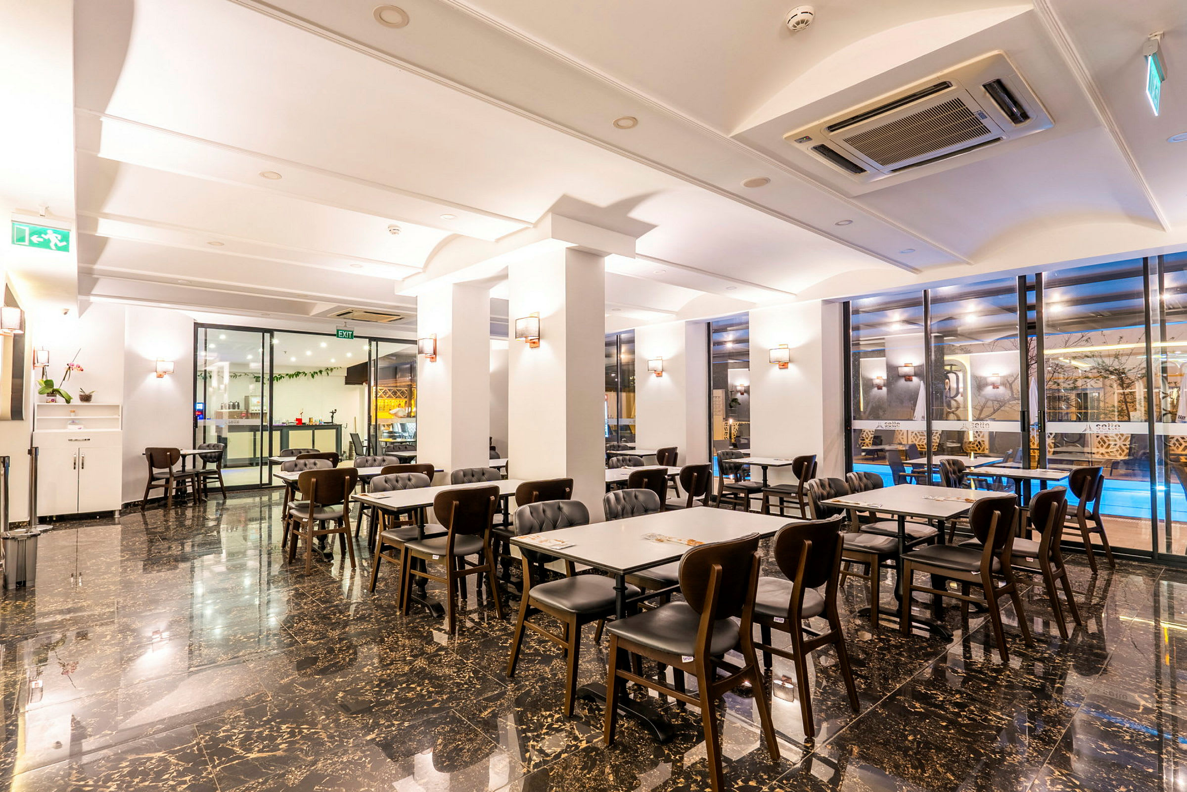 Et godt oplyst restaurantområde med borde og stole placeret på en blank gulvoverflade. (AI-genereret tekst)