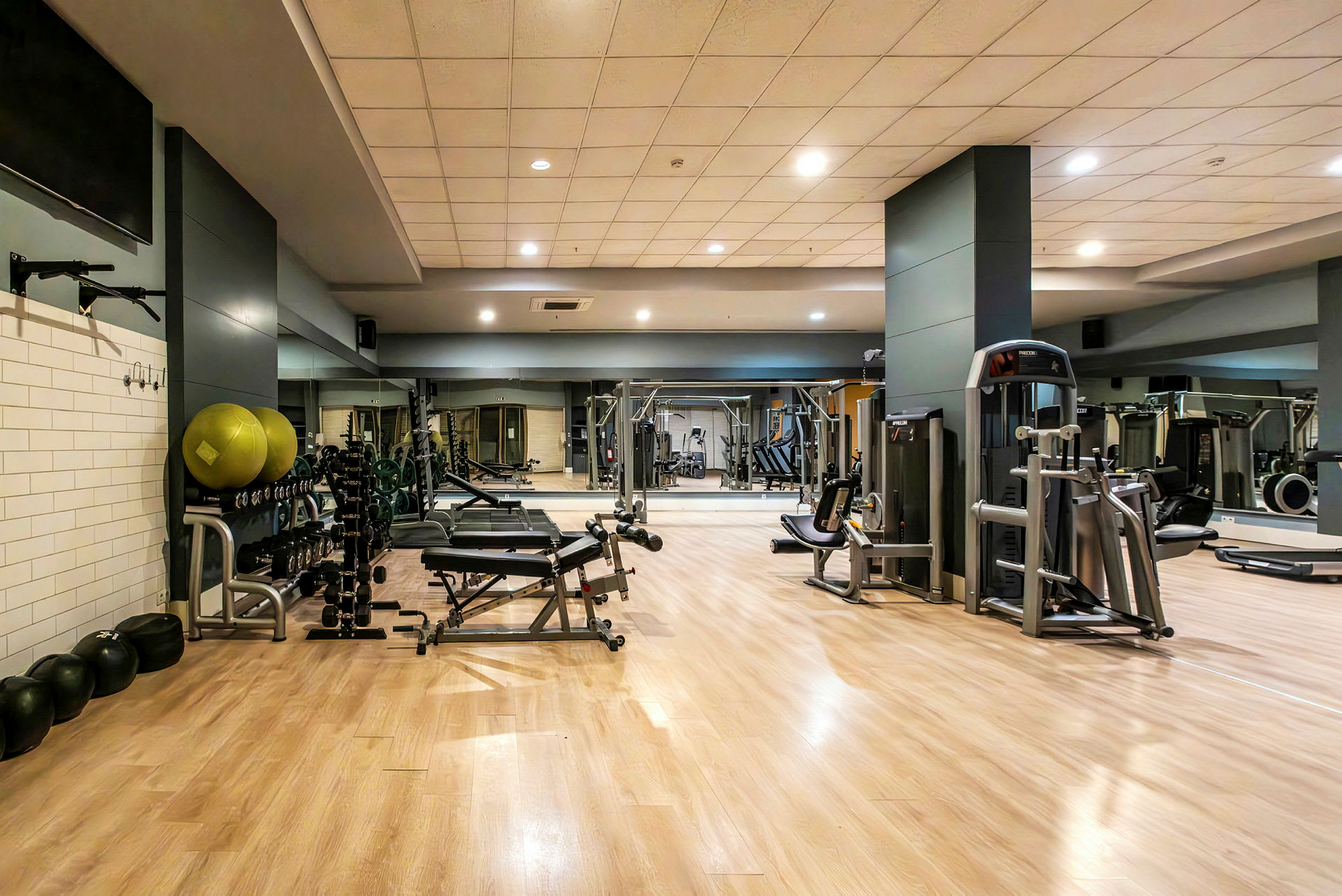 Fitnesscenter med træningsmaskiner og frie vægte. (AI-genereret tekst)