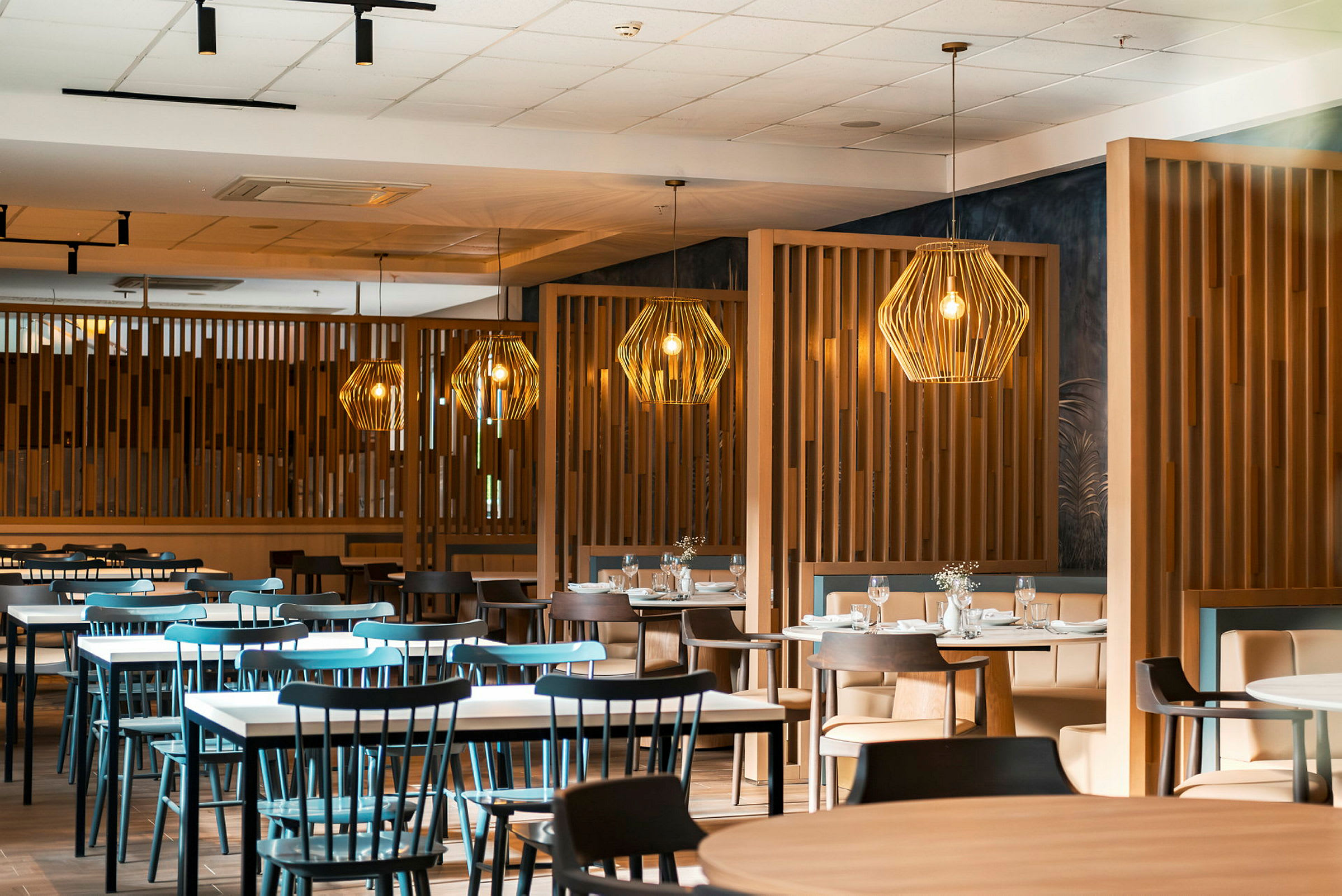 En restaurant med flere borde og stole samt dekorative lamper. (AI-genereret tekst)