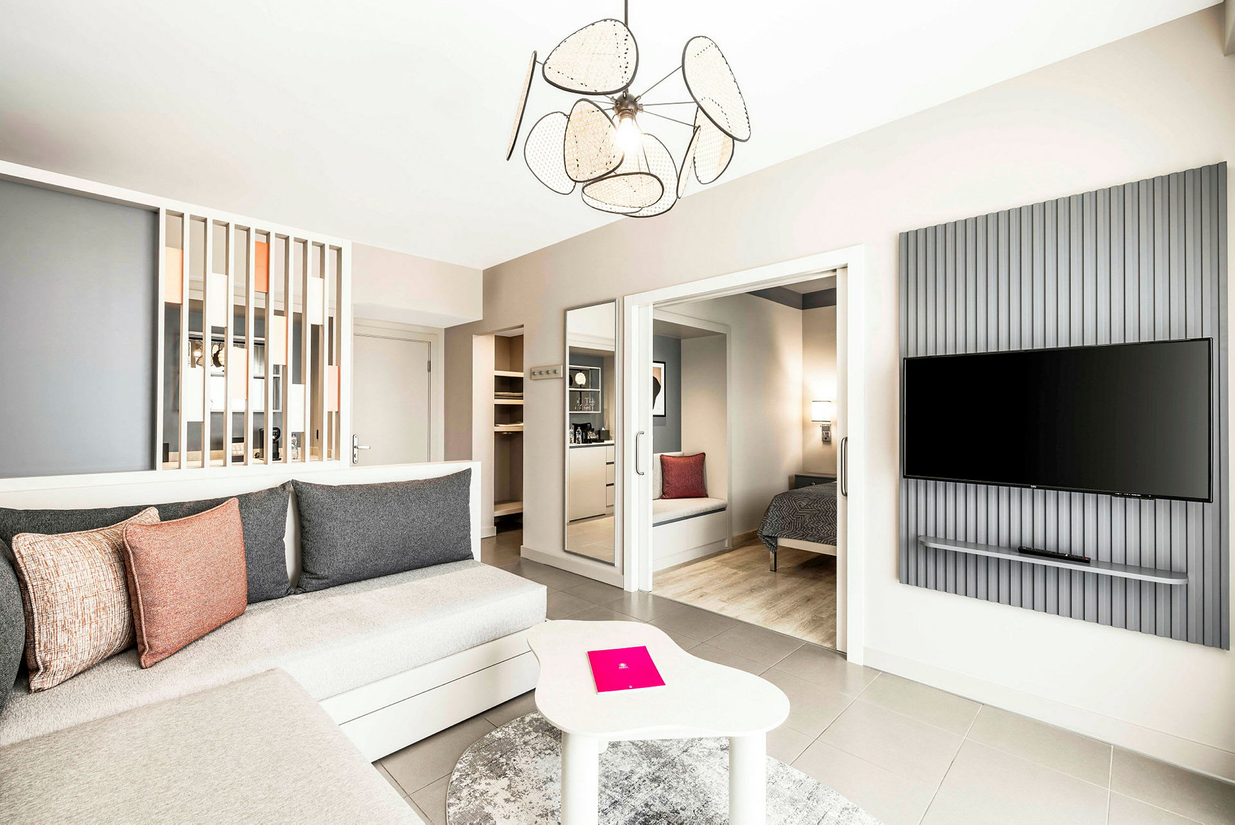 Et rummeligt og moderne indrettet hotelværelse med siddeområde, soveplads og en vægmonteret TV. (AI-genereret tekst)