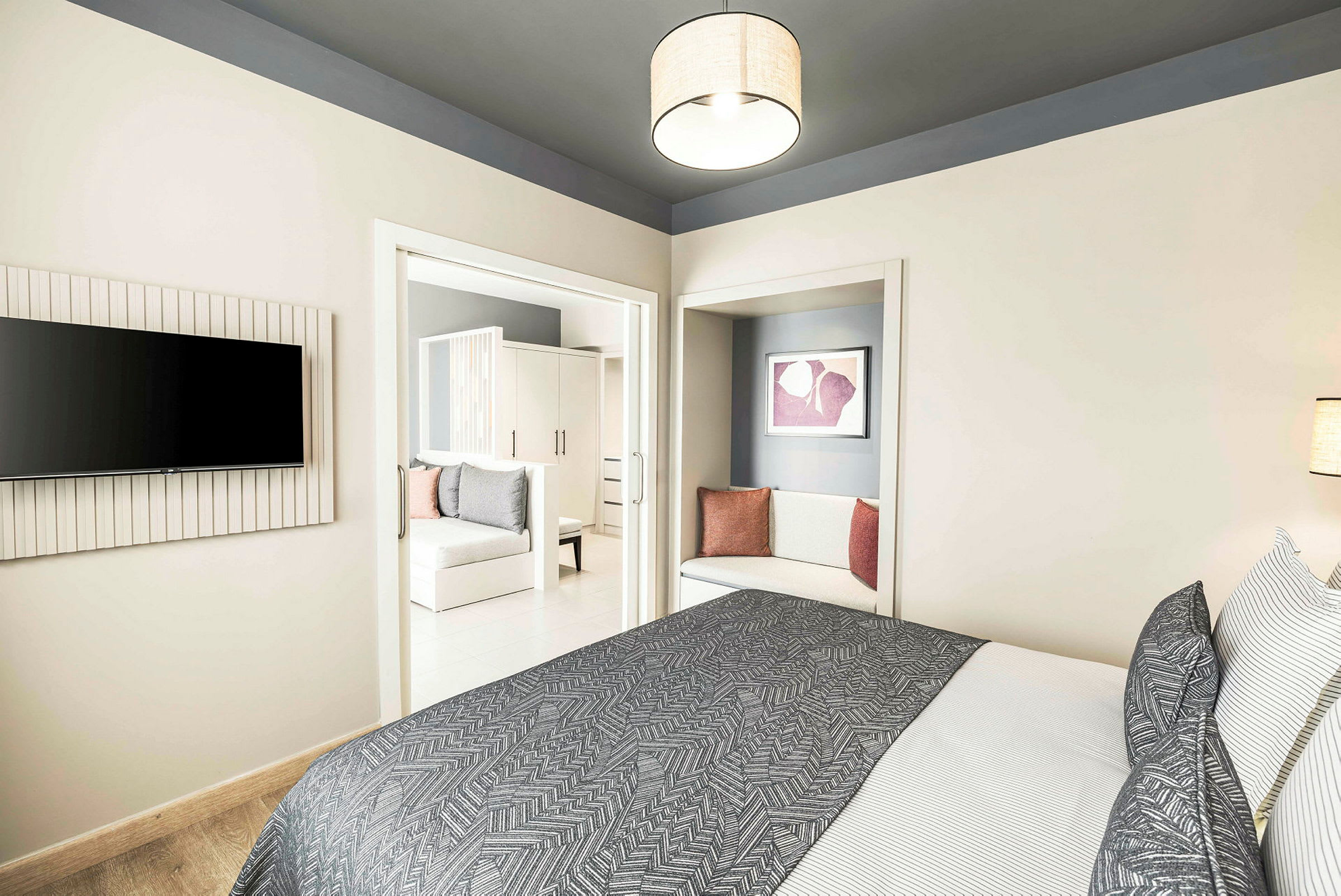 Moderne hotelværelse med seng, tekstiler og siddeområde. (AI-genereret tekst)