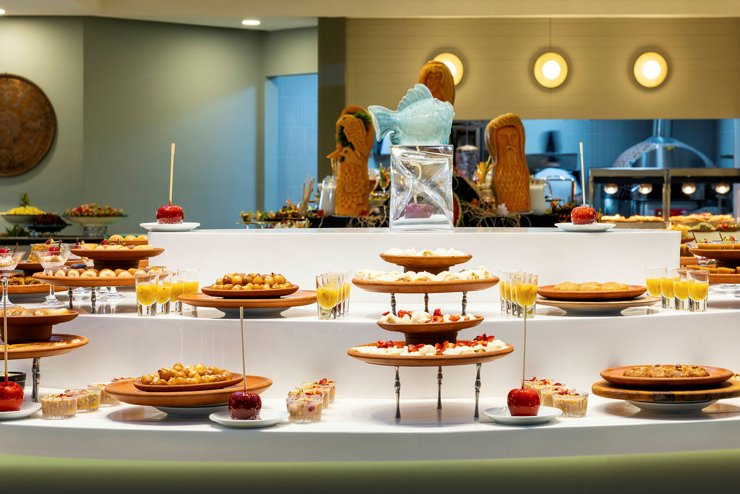 En buffet med forskellige desserter og frugter anrettet på tallerkener og glas. (AI-genereret tekst)