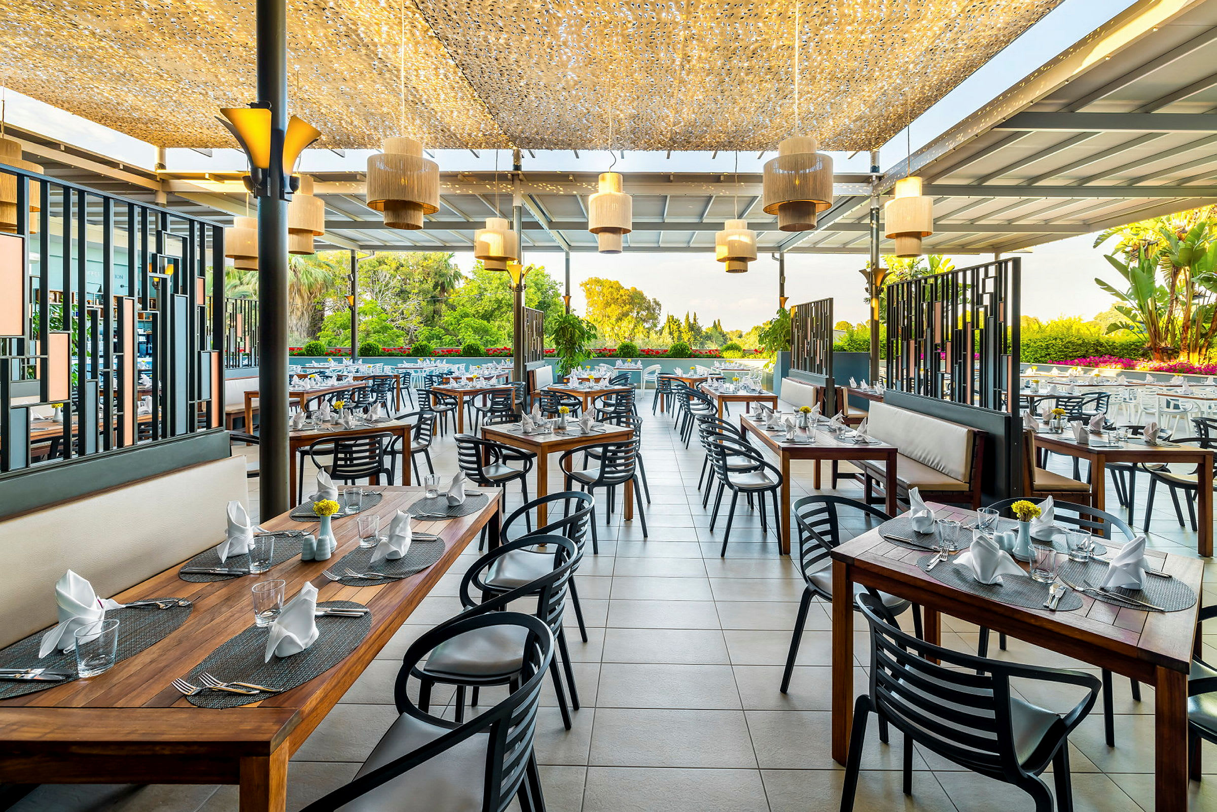 Restaurant med udendørs servering og moderne møbler, borde med opdækning. (AI-genereret tekst)