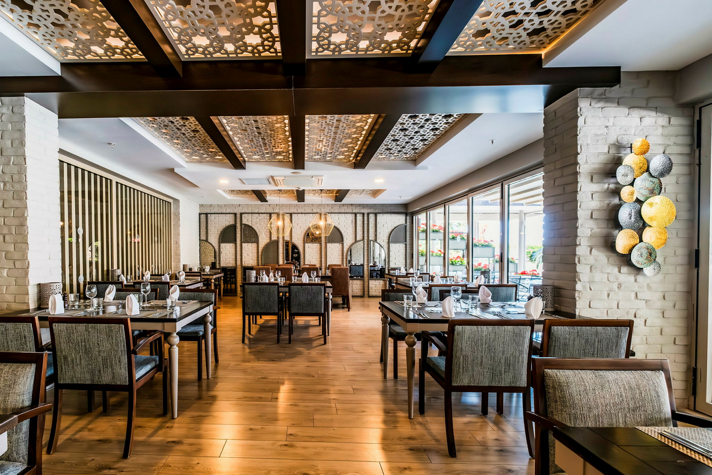 Indretning af en elegant restaurant med moderne møbler og dekorative loftdetaljer. (AI-genereret tekst)