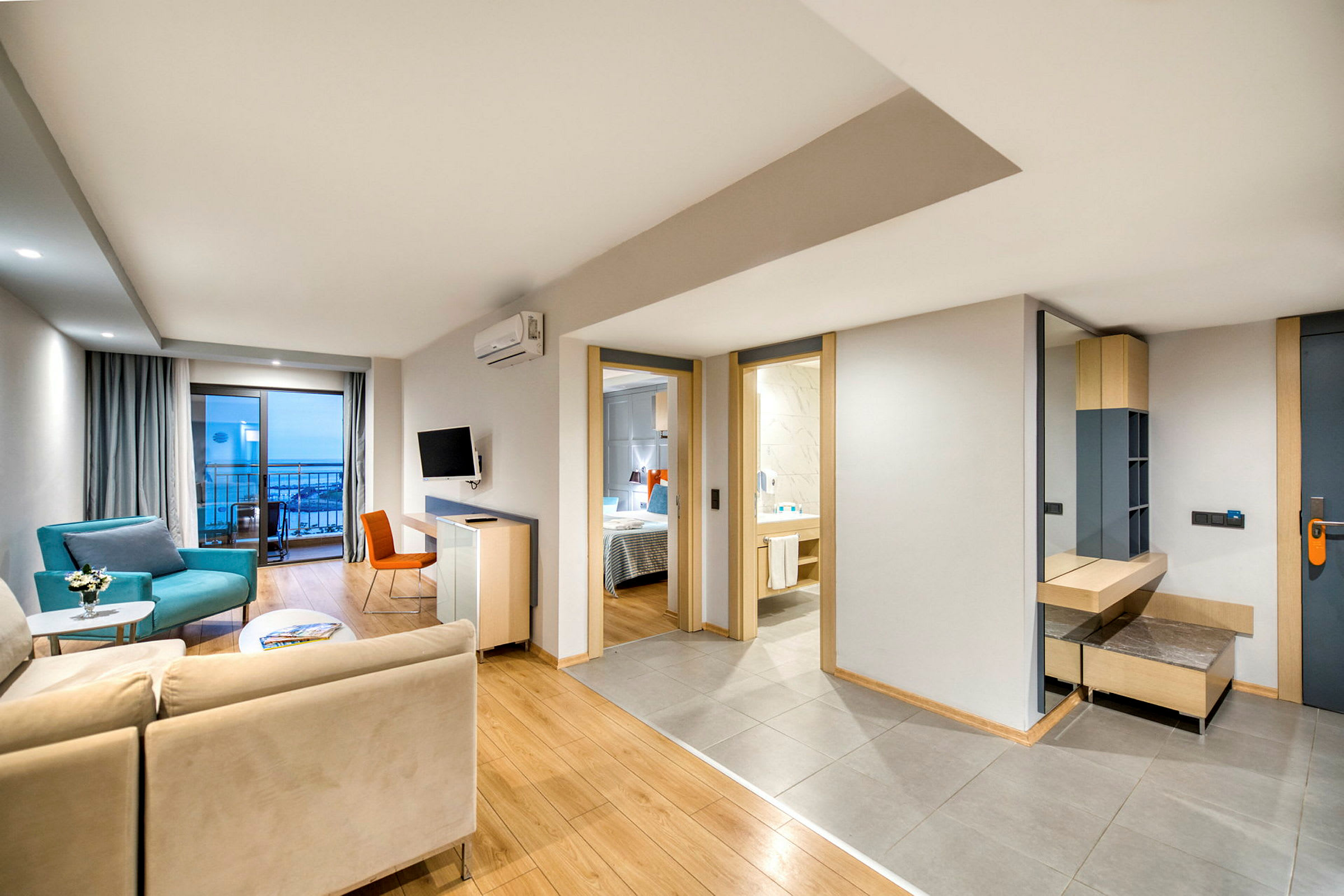 Billede af en moderne hotelsuite med siddeområde, soveværelse og badeværelse. (AI-genereret tekst)