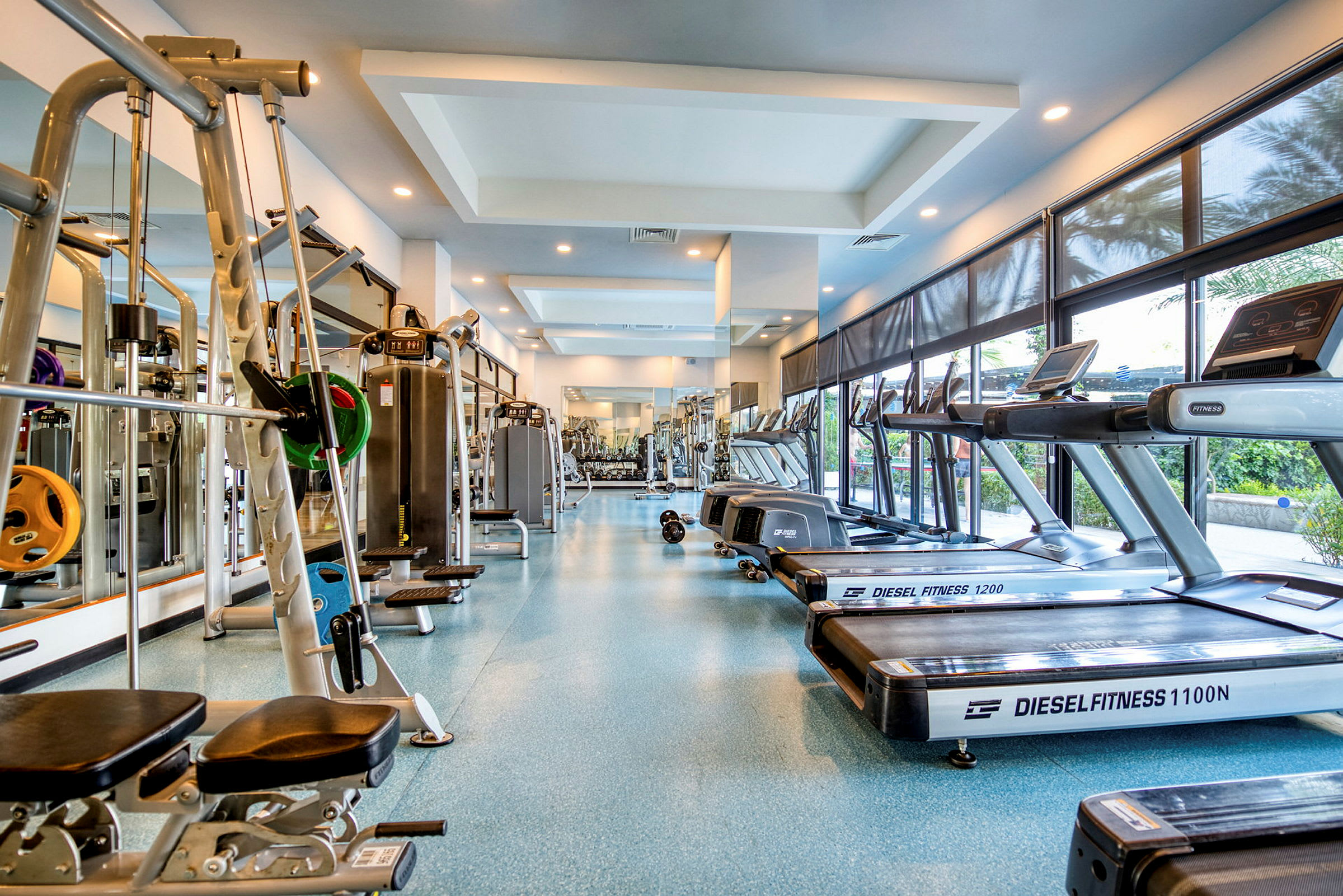 Billede af et fitnesscenter med træningsudstyr som løbebånd og styrketræningsmaskiner. (AI-genereret tekst)