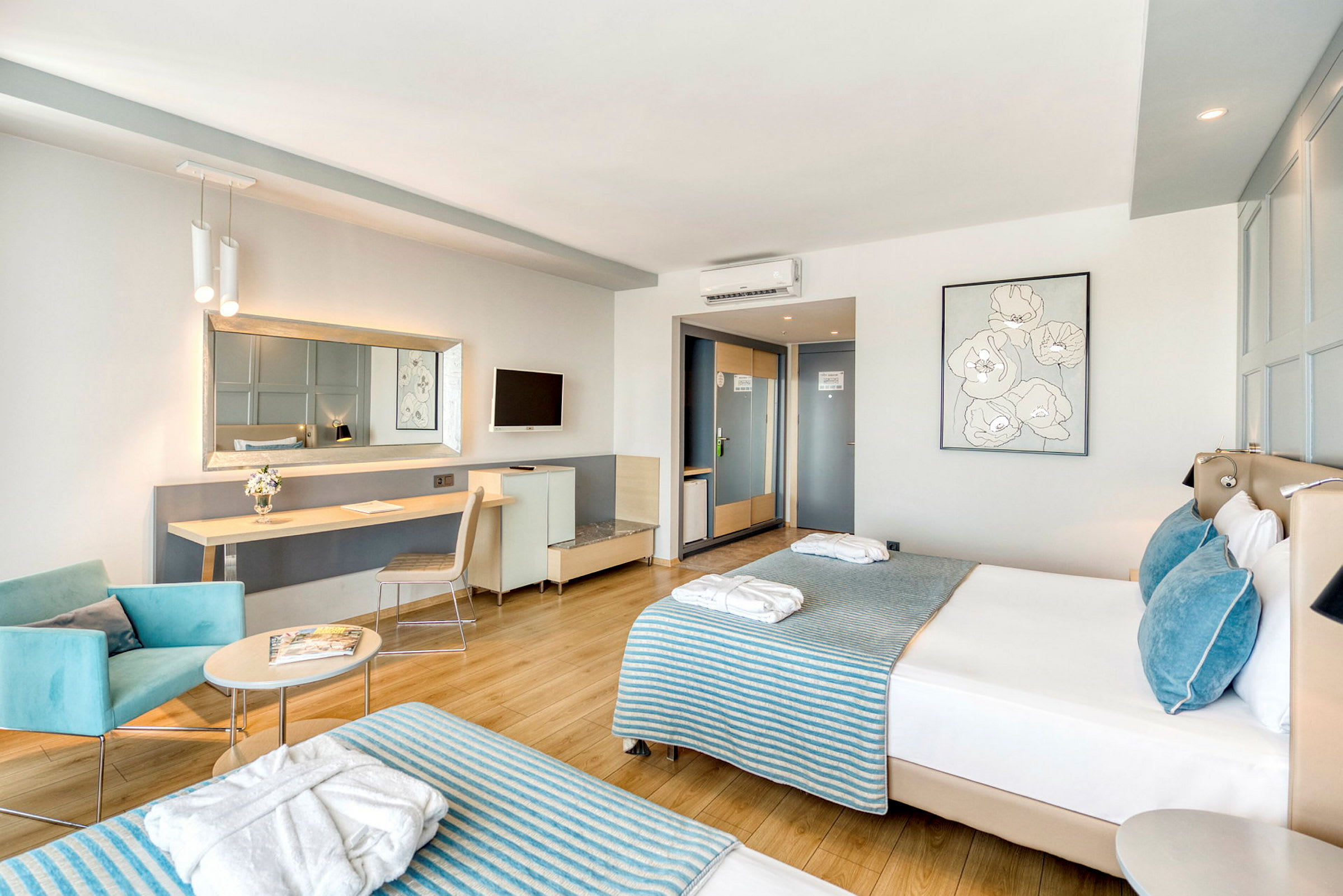 Moderne hotelværelse med to senge, siddeområde og arbejdsbord. (AI-genereret tekst)
