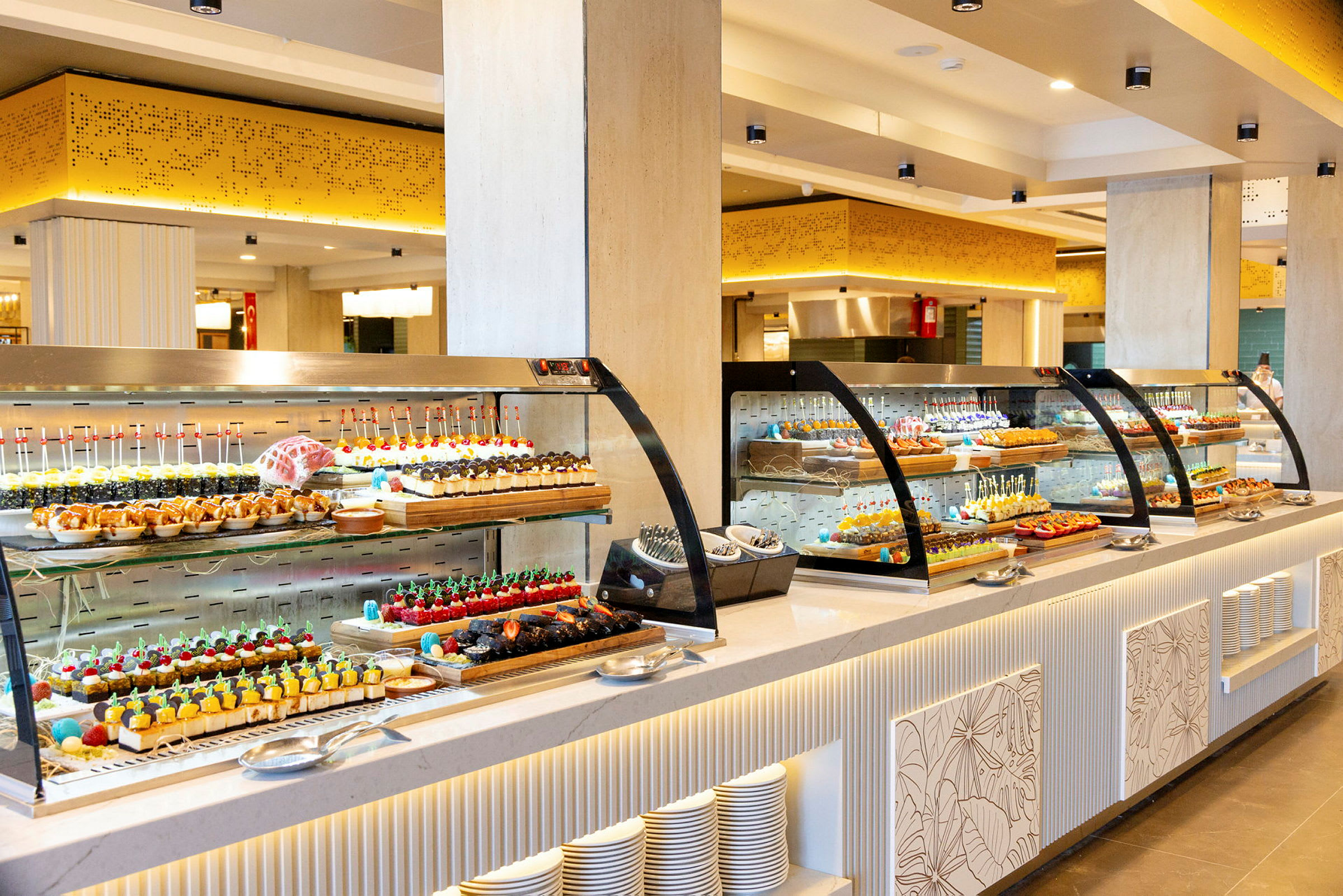 En buffet med forskellige desserter og kager i et lyst indrettet rum. (AI-genereret tekst)