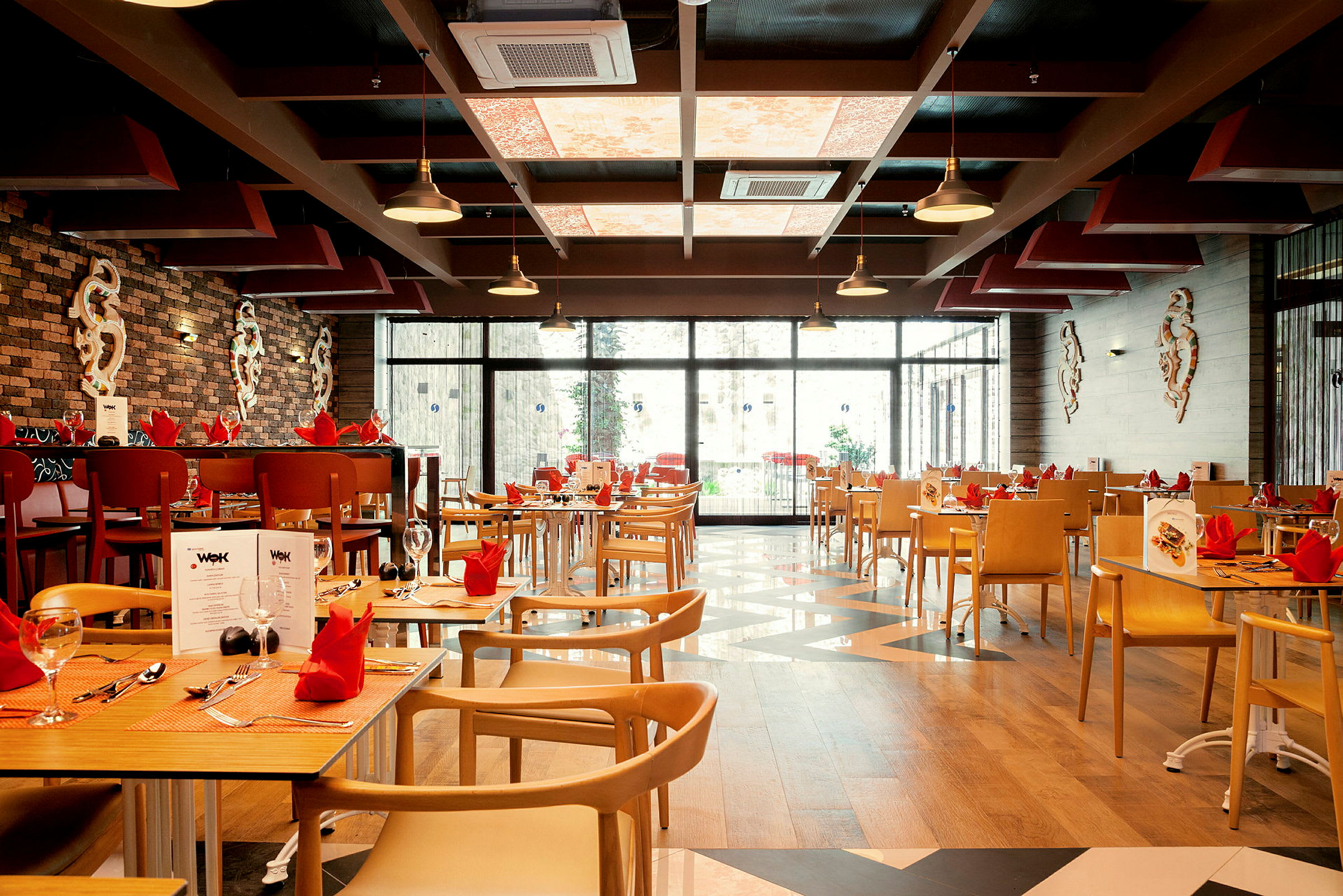 Restaurant med dækkede borde og vinduer i baggrunden. (AI-genereret tekst)