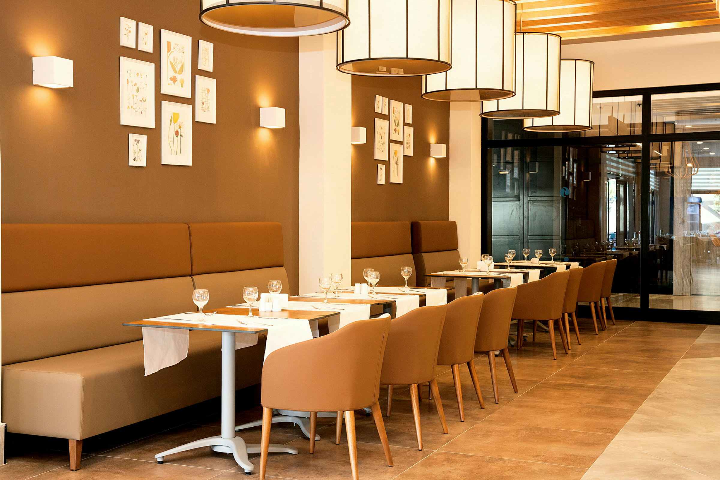 En restaurant med siddepladser og borde dækket med glas og servietter. (AI-genereret tekst)