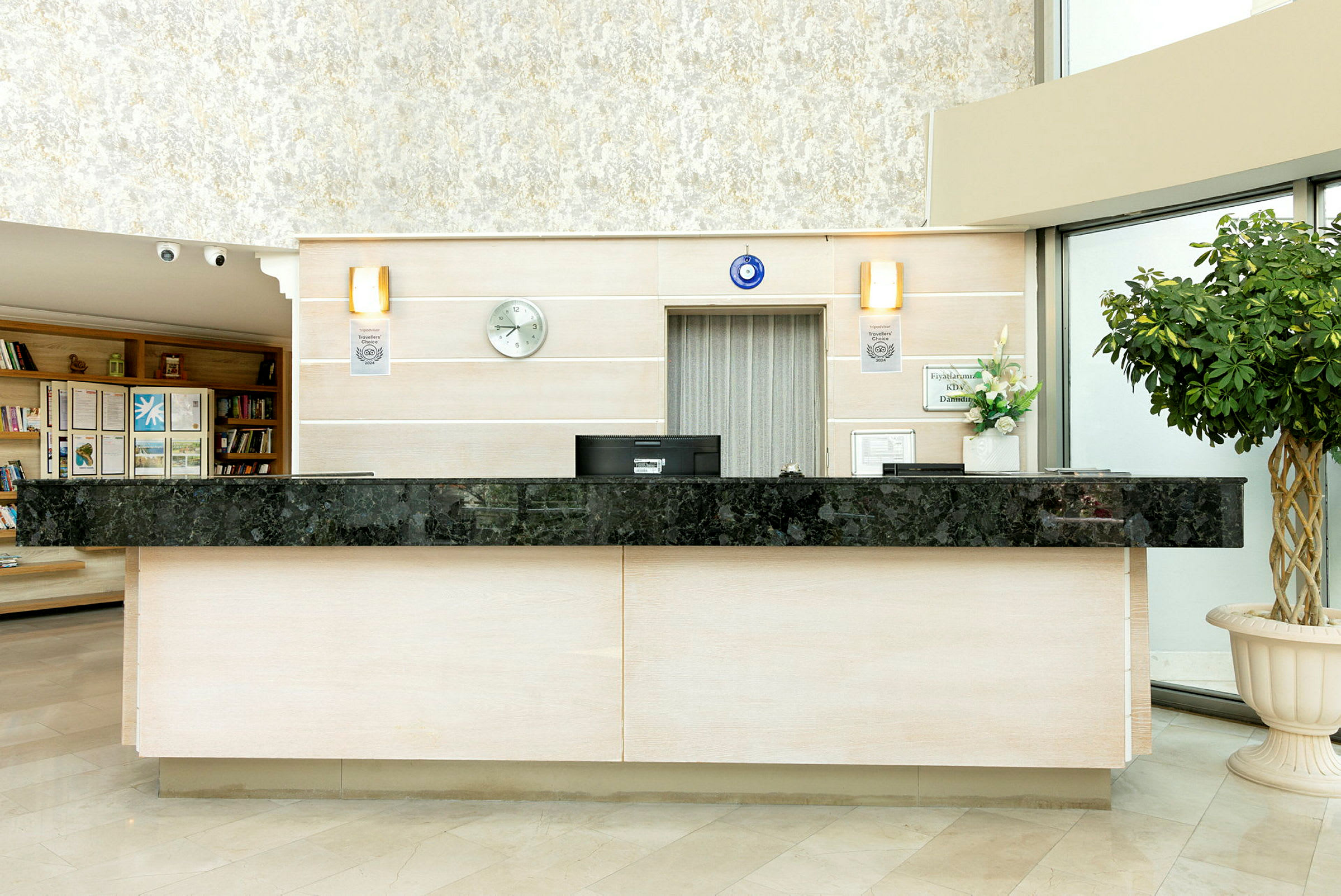 Hotelreception med sort marmorbordplade, beige vægge og en grøn plante til højre. (AI-genereret tekst)