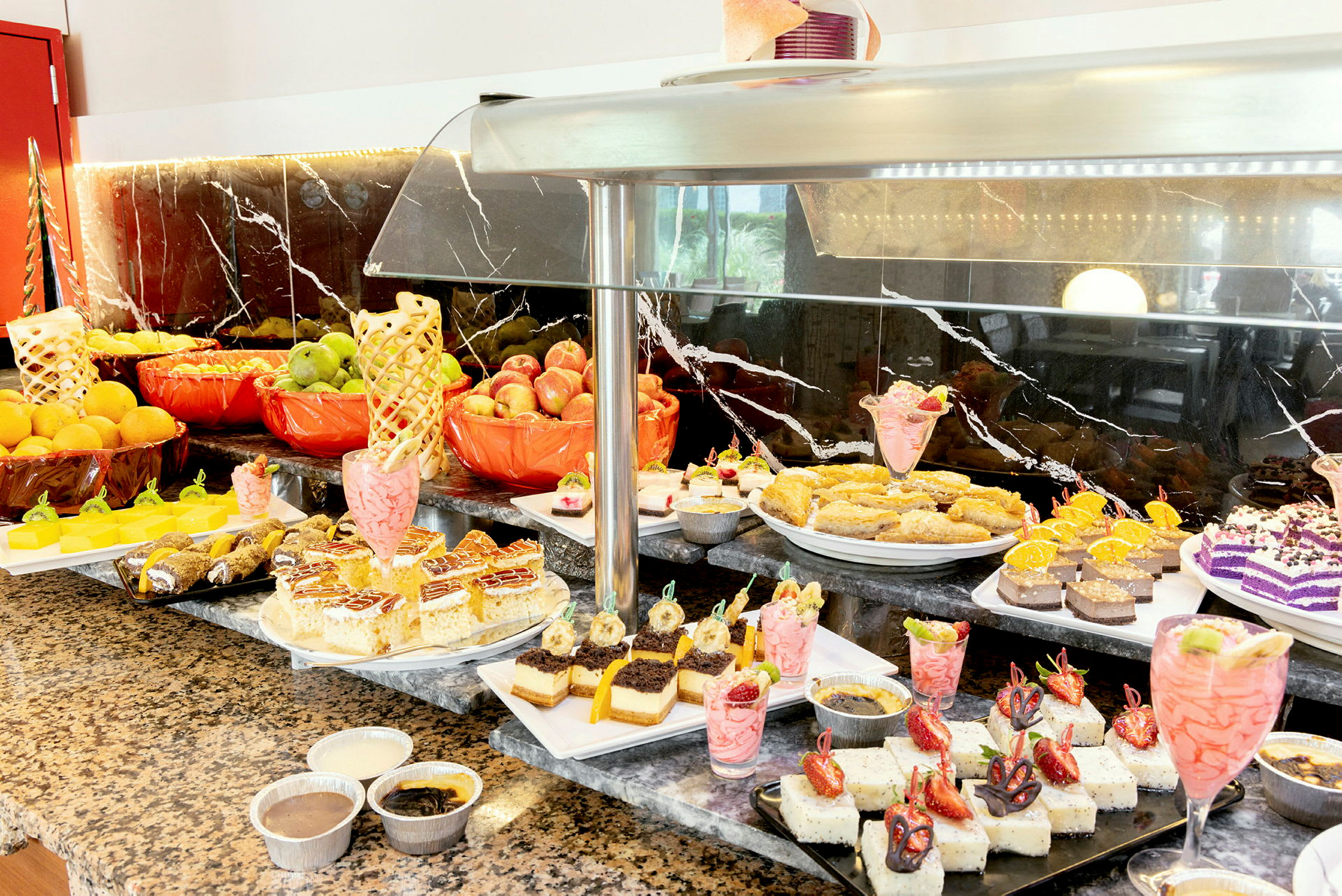 Buffet med forskellige desserter og frisk frugt. (AI-genereret tekst)