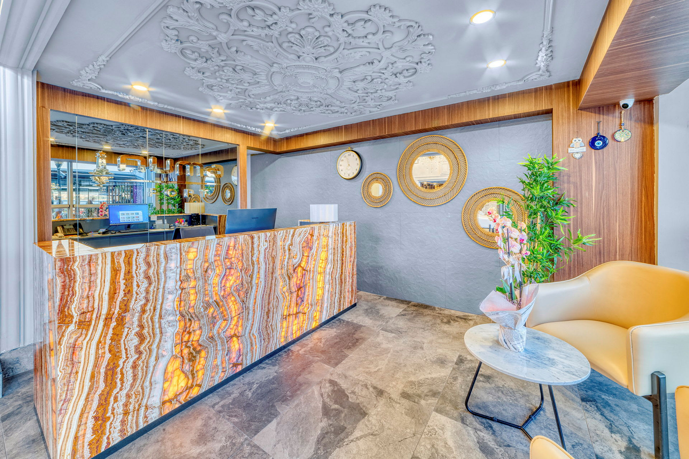Reception med marmorlignende frontpanel, dekoreret loftdesign og spejle på væggen. (AI-genereret tekst)