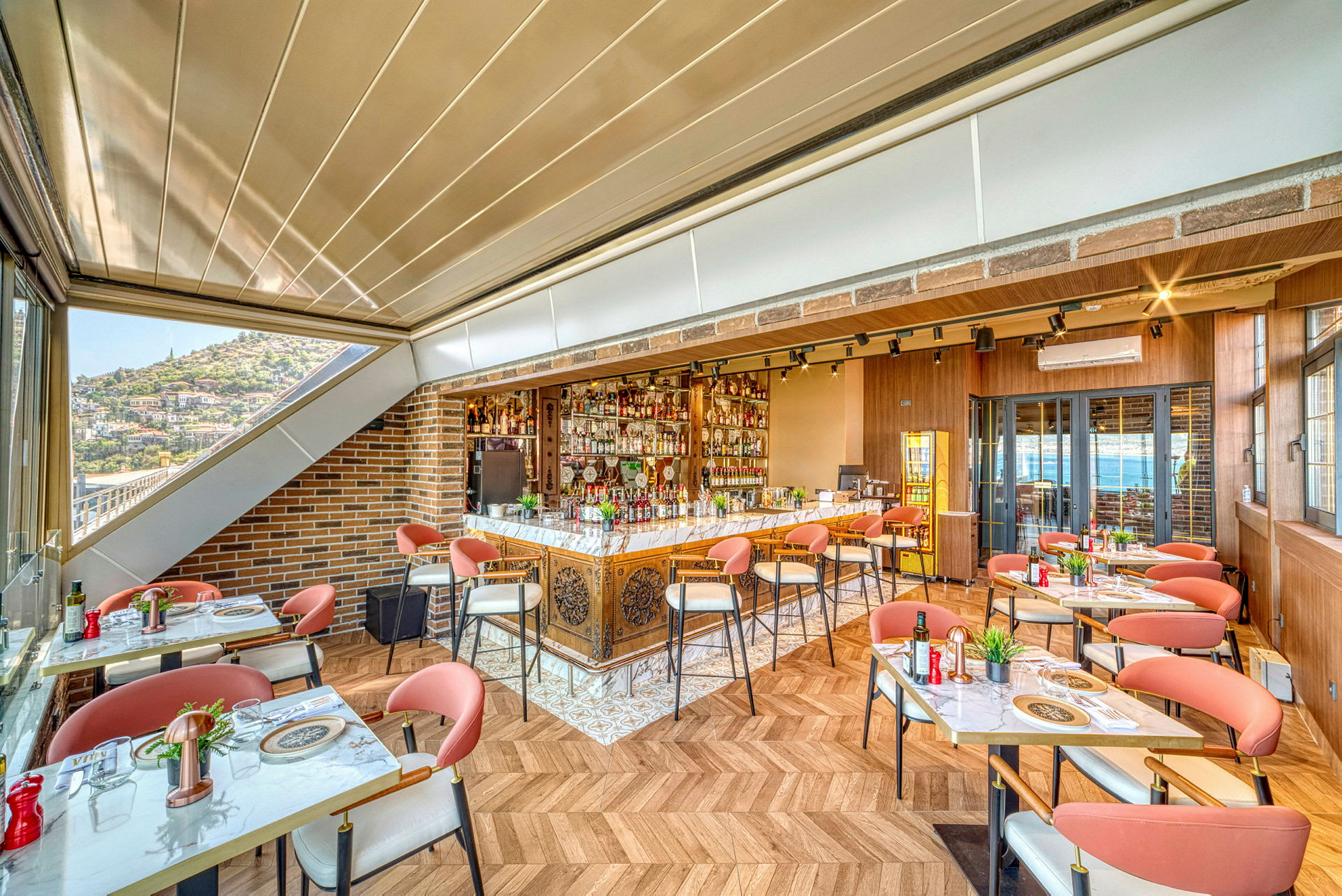 En lys restaurantindretning med moderne møbler og udsigt gennem store vinduer. (AI-genereret tekst)