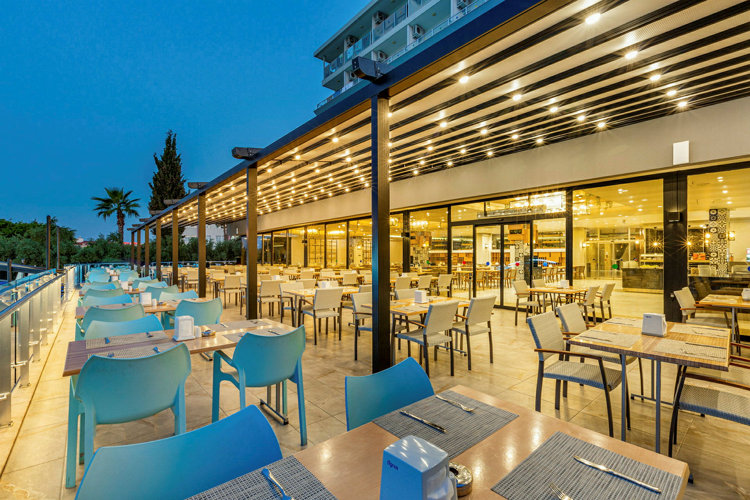 Udendørsserveringen ved en moderne restaurant om aftenen. (AI-genereret tekst)