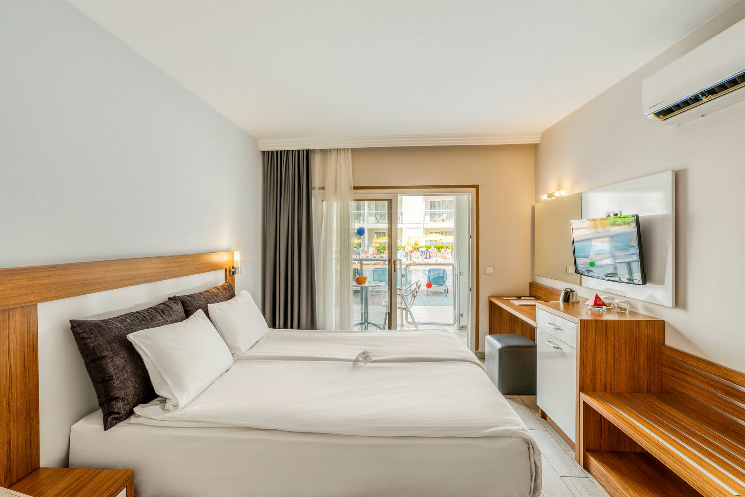 Hotelværelse med dobbeltseng og balkon. (AI-genereret tekst)