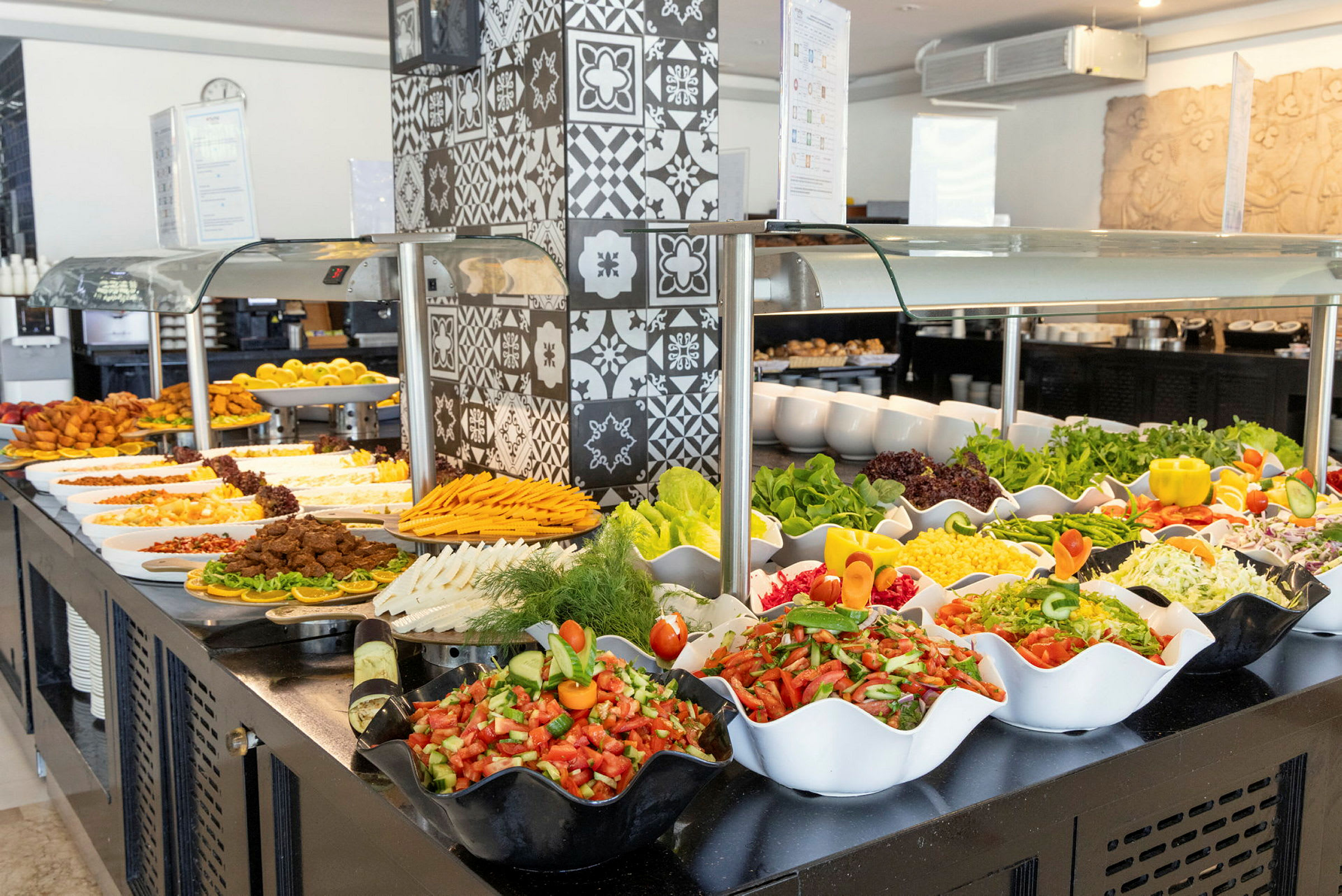 En buffet med forskellige retter, herunder salater, grøntsager og andre tilbehør, med dekorationer og fade placeret på en serveringsflade. (AI-genereret tekst)
