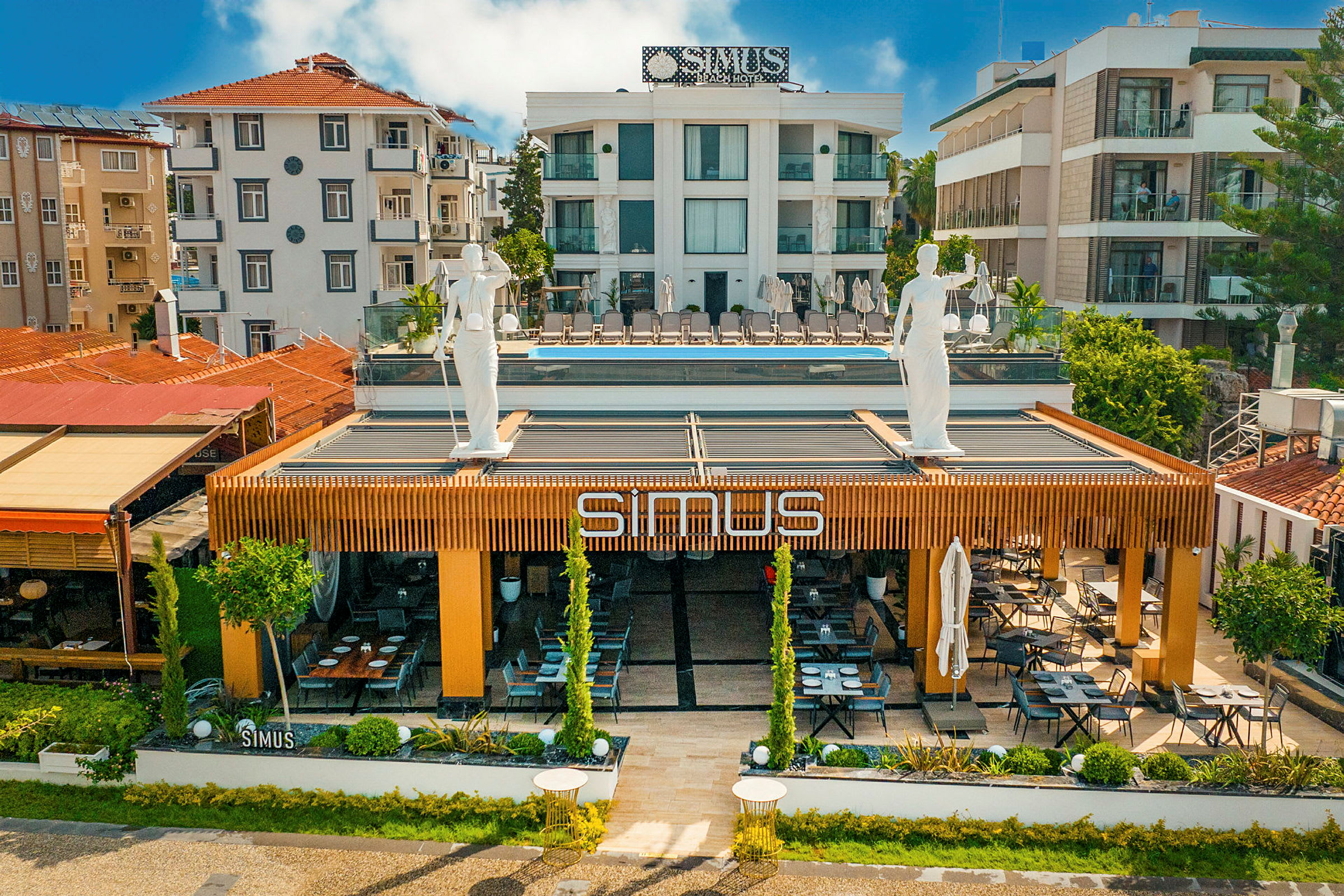 Fasaden på en bygning med en restaurant med navnet "SIMUS". (AI-genereret tekst)