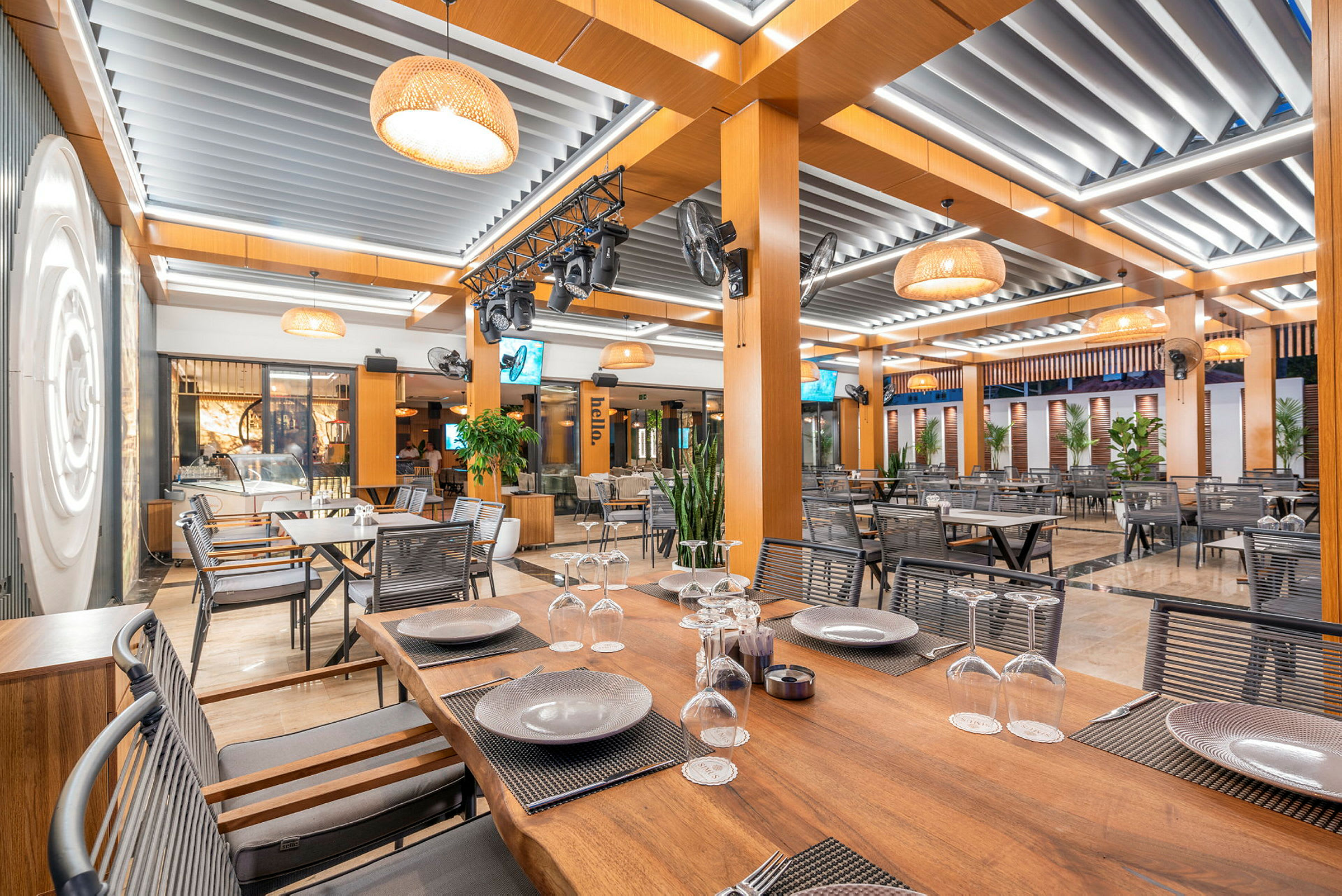 Indendørsmiljø i en moderne restaurant med træborde og loftdekoration. (AI-genereret tekst)