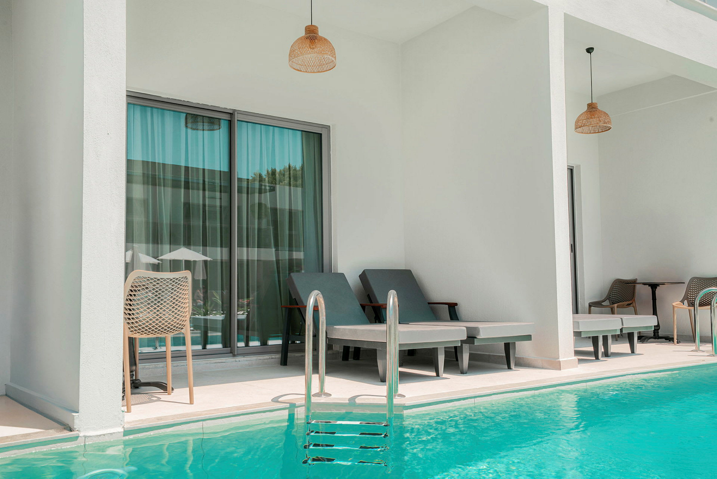 To liggestole ved en pool, med en terrasse i baggrunden. (AI-genereret tekst)