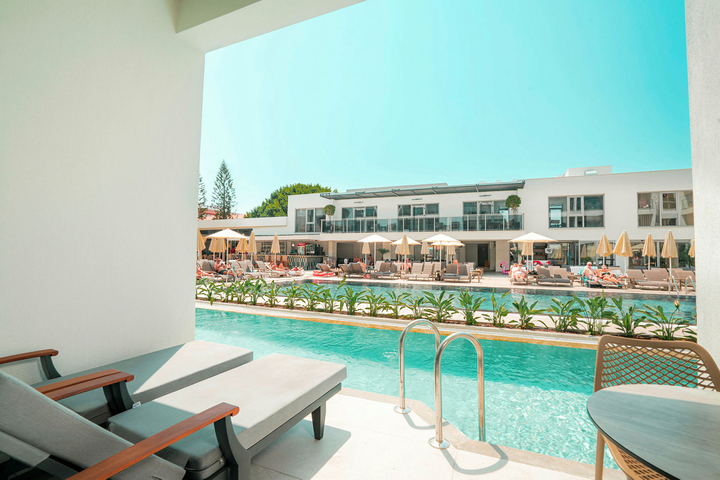 Privat poolområde med udsigt til et moderne hotelkompleks. (AI-genereret tekst)