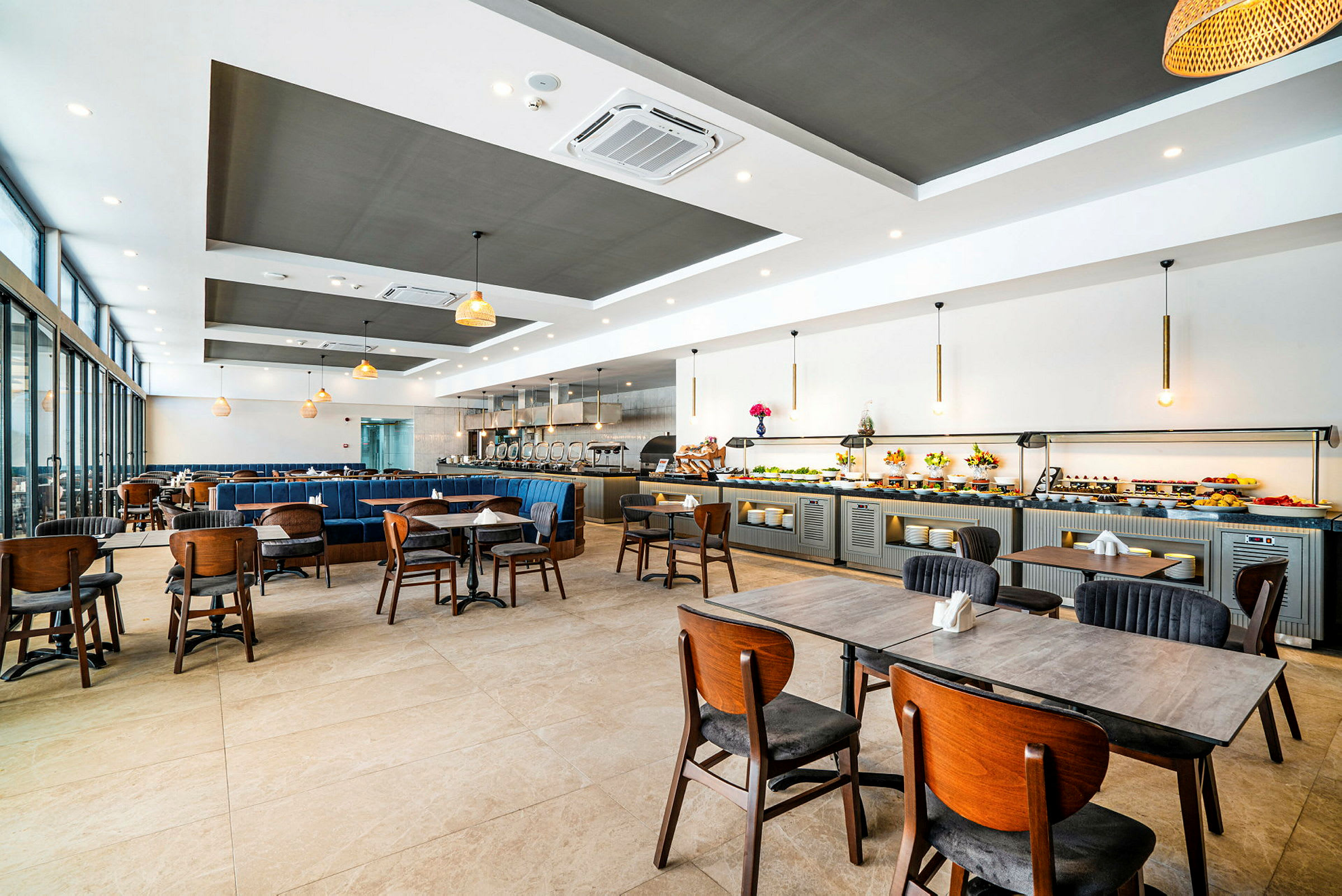 En rummelig restaurant med borde og stole samt en buffédisk langs væggen. (AI-genereret tekst)