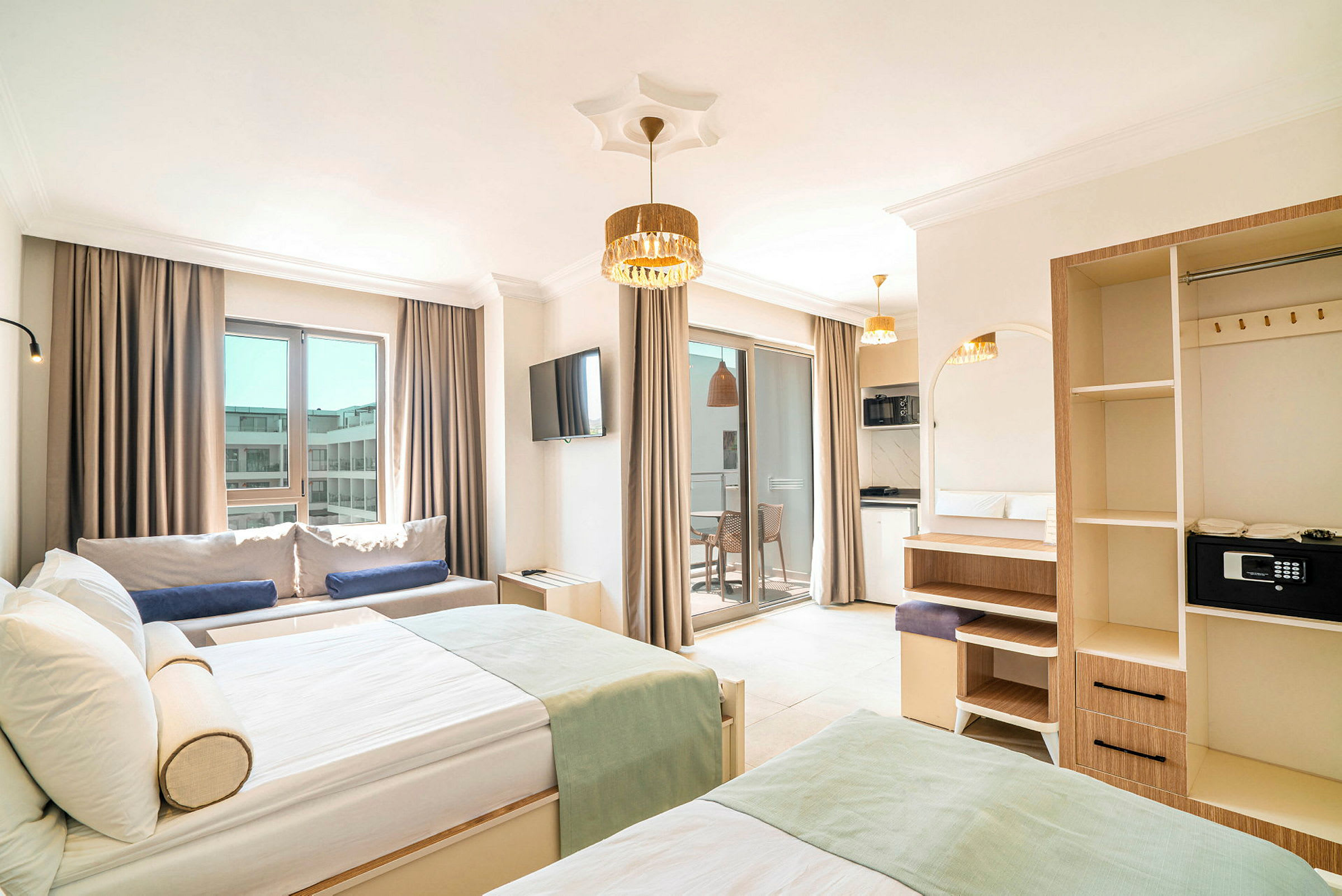 Billede af et hotelværelse med moderne møbler, to senge, en sofa, et tv og en balkon med lyse gardiner. (AI-genereret tekst)