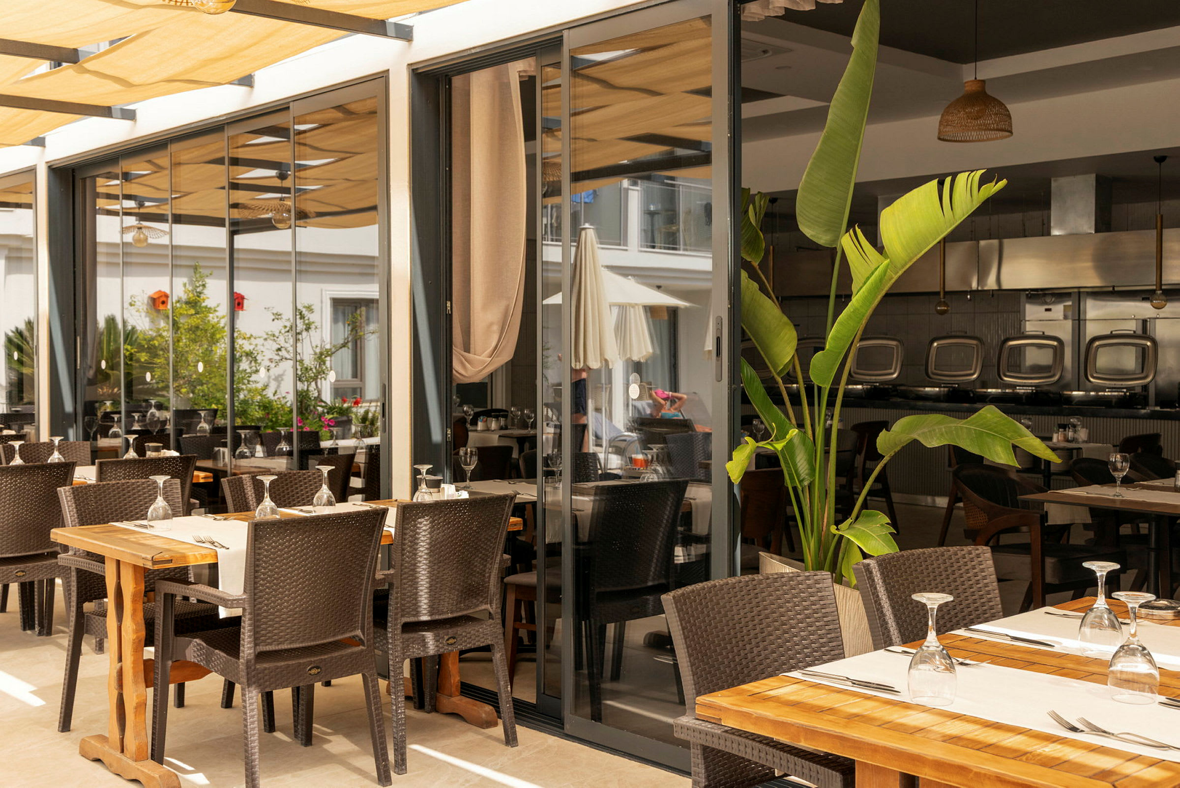 Terrasse med udendørsservering, træmøbler og planter. (AI-genereret tekst)