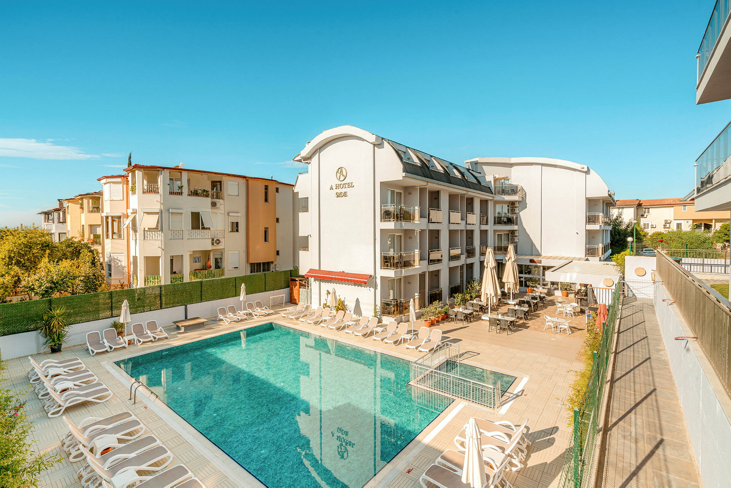 En bygning med hotelfaciliteter ved en udendørs pool. (AI-genereret tekst)