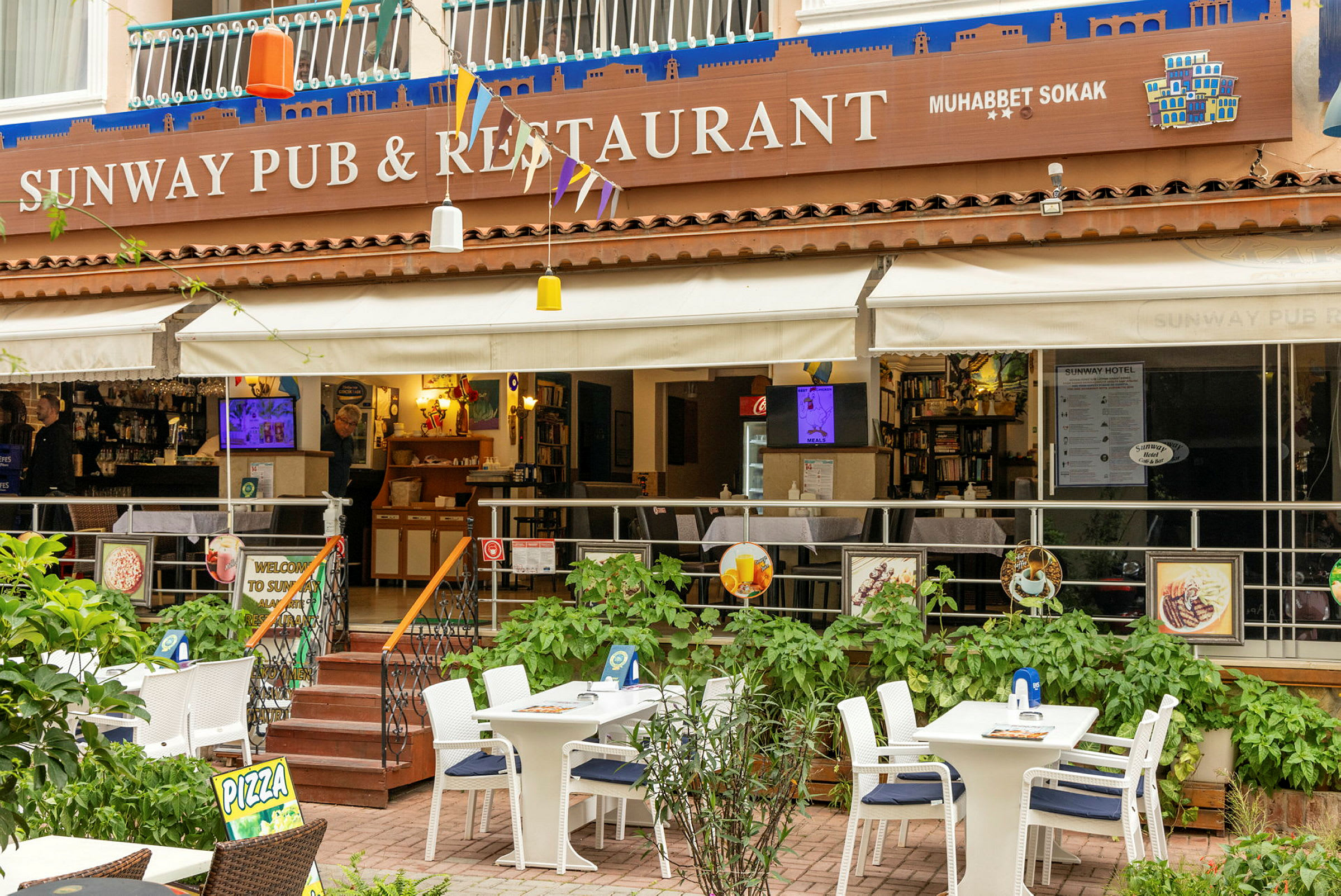 En udendørs terrasse af en restaurant med borde og stole. (AI-genereret tekst)