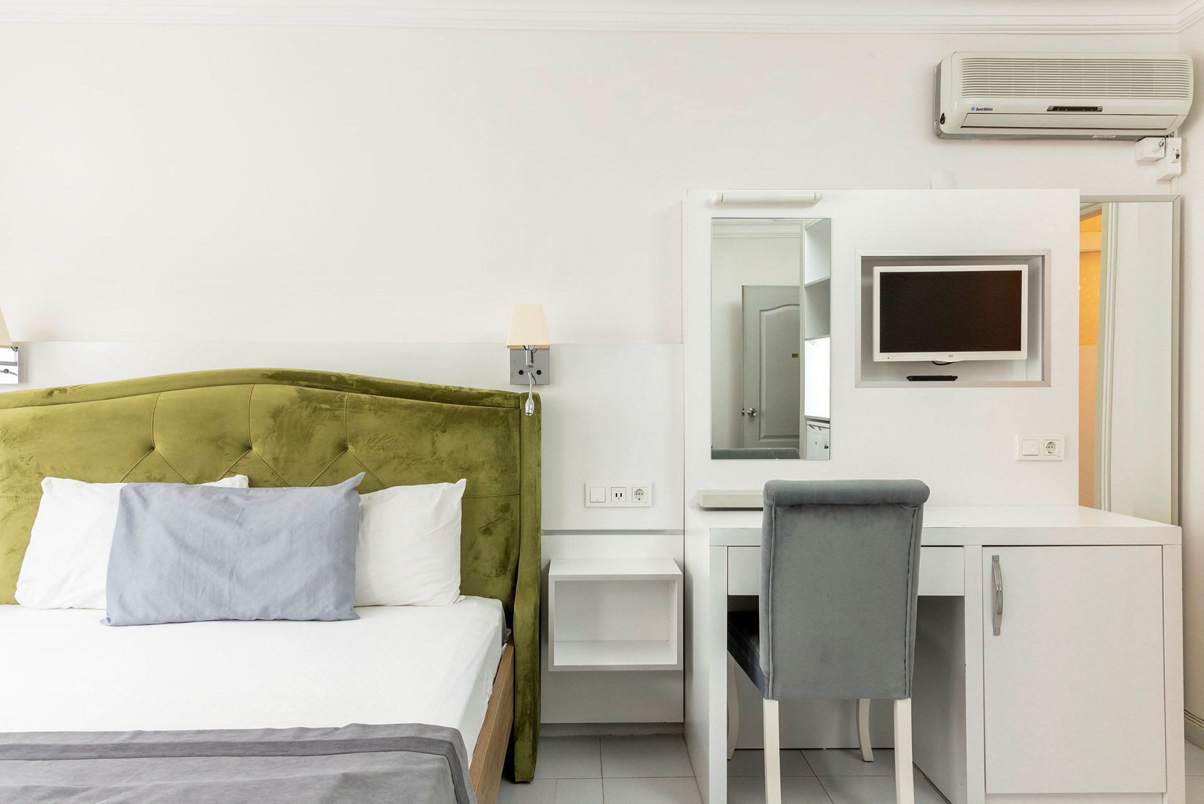 Hotelværelse med en seng og skrivebord med stol. (AI-genereret tekst)