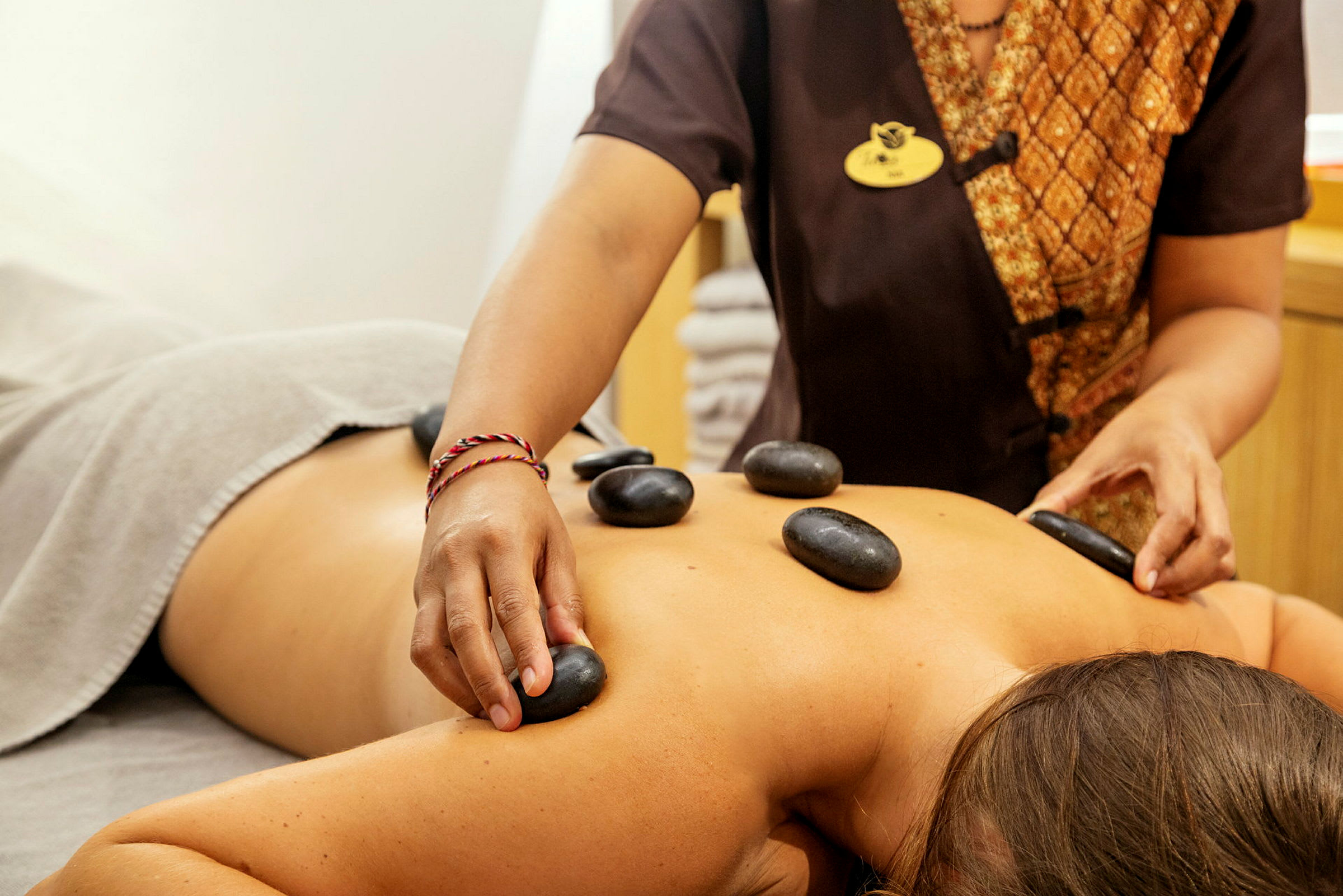 En person modtager hot stone-massage. (AI-genereret tekst)