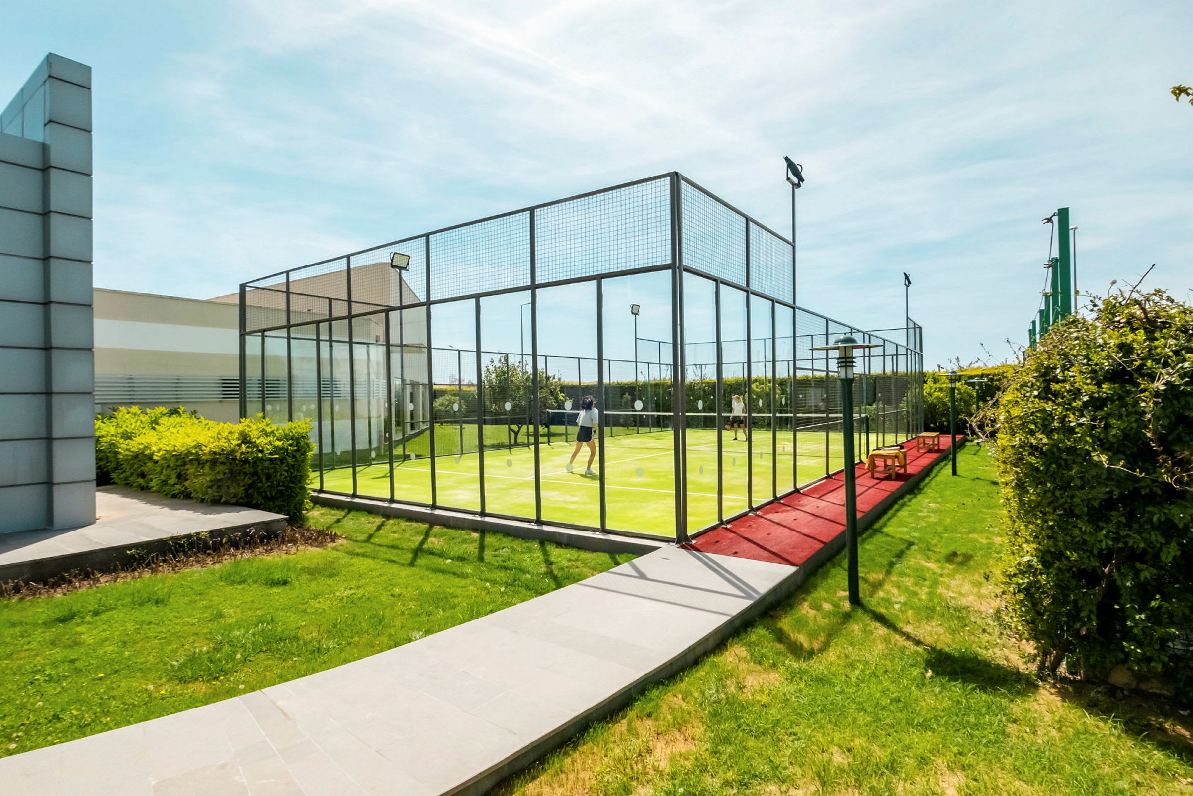 Personer spiller padel på en udendørs bane. (AI-genereret tekst)