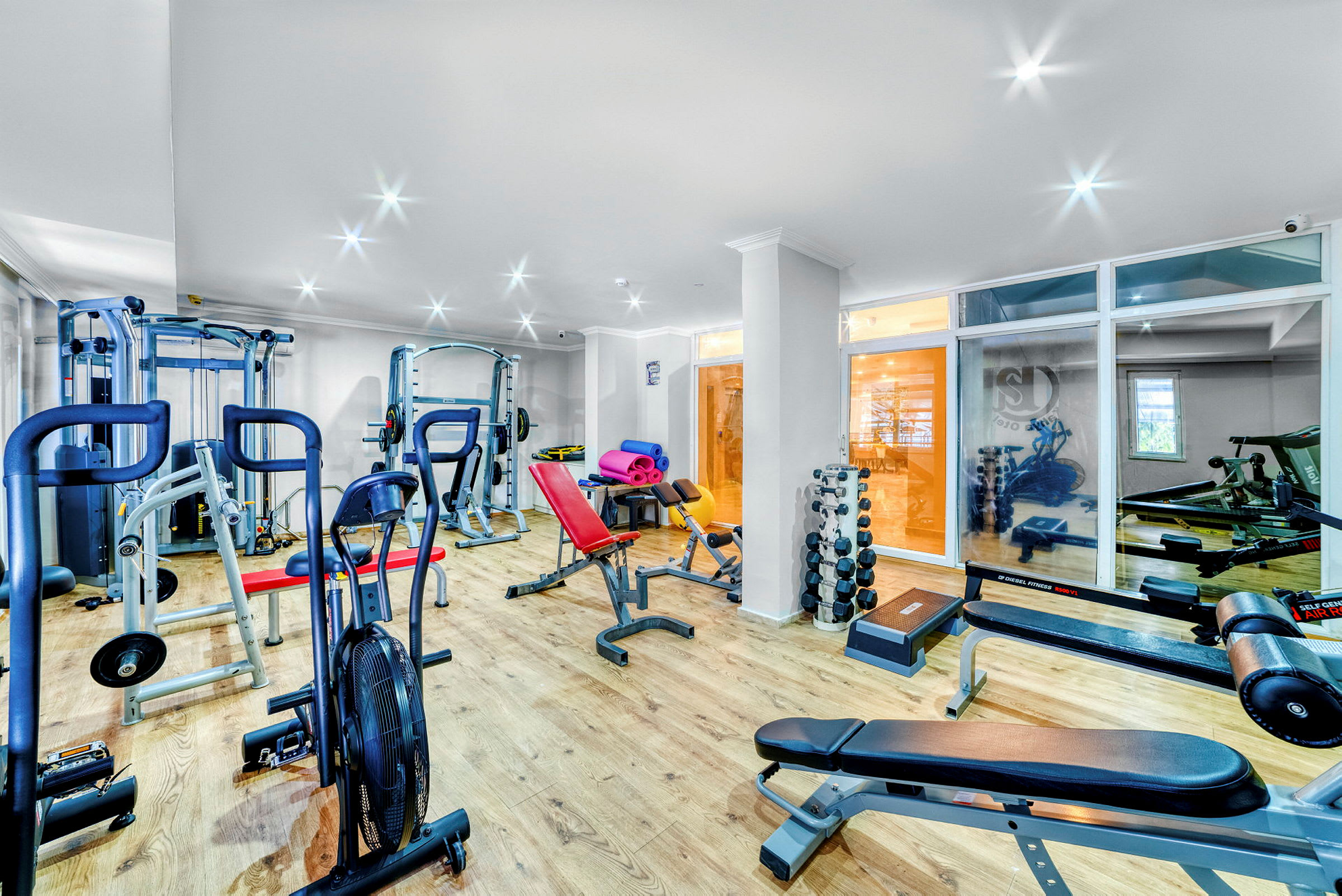 Et fitnesscenter med træningsudstyr og håndvægte. (AI-genereret tekst)