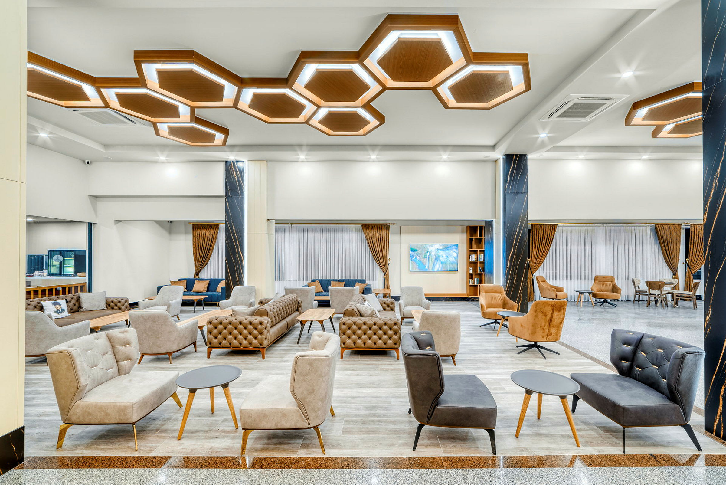 Moderne hotellobby med elegante siddearrangementer og geometriske loftslamper. (AI-genereret tekst)