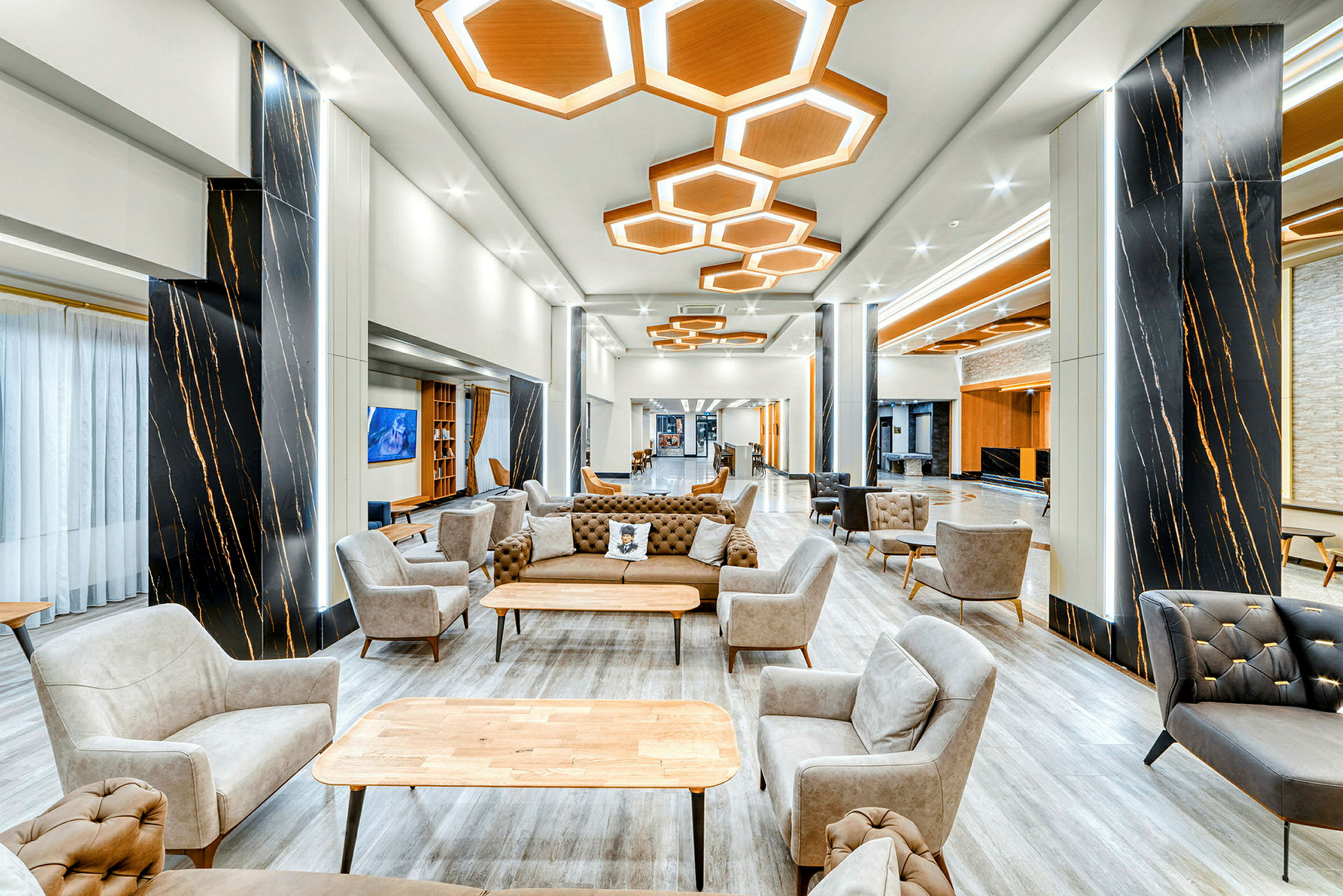 En moderne og velbelyst lounge med stole og sofaer foran et bord. (AI-genereret tekst)