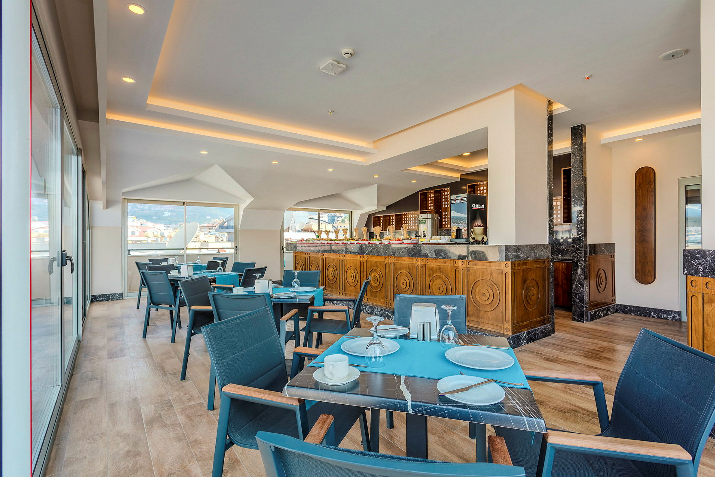 Restaurant med spiseborde og stole samt serveringsområde med trædesign. (AI-genereret tekst)