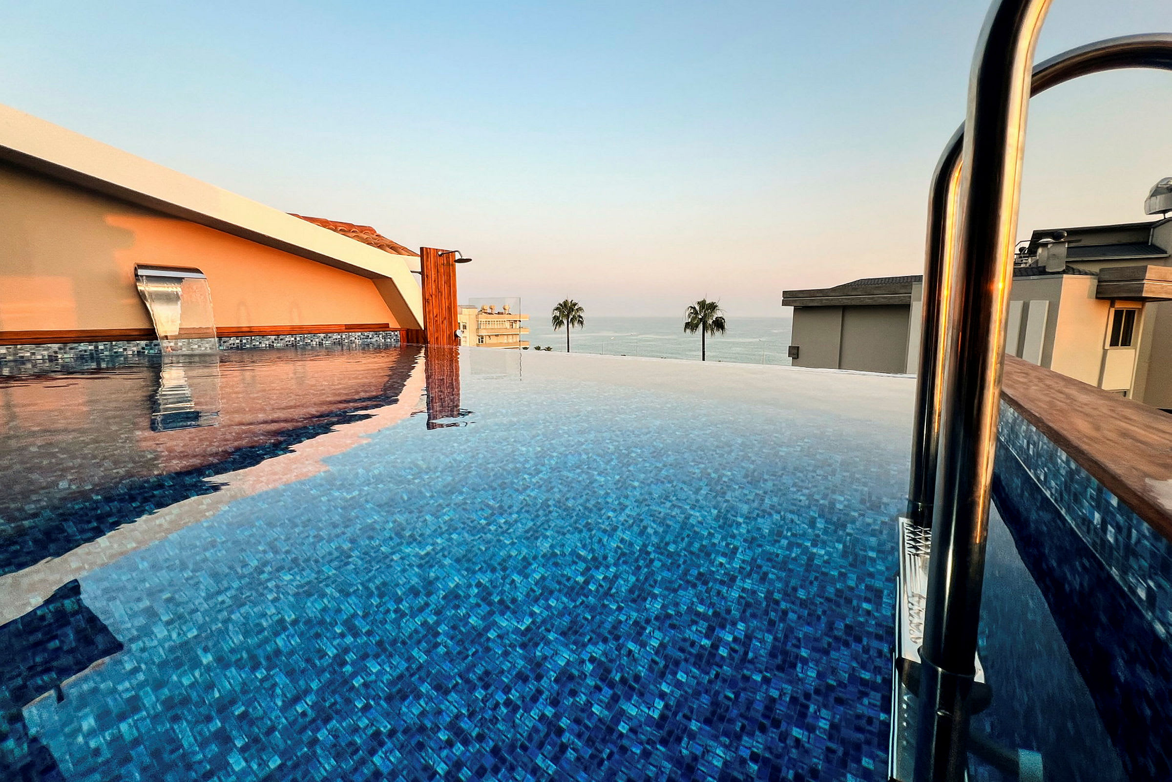 Infinitypool ved solnedgang med udsigt over havet. (AI-genereret tekst)