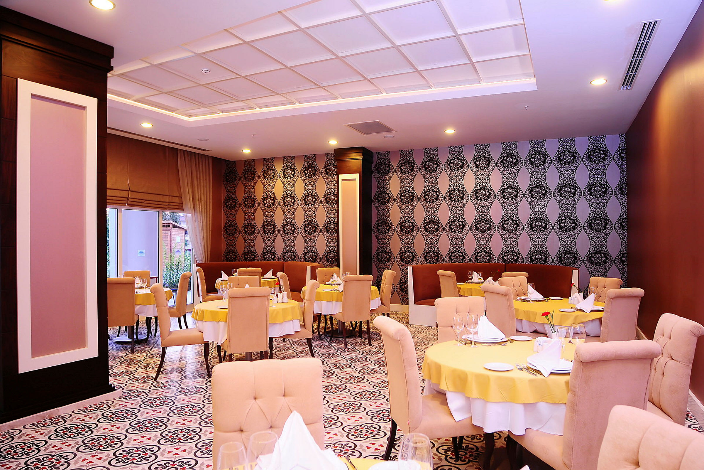 Restaurant med borddækning og dekorerede vægge. (AI-genereret tekst)