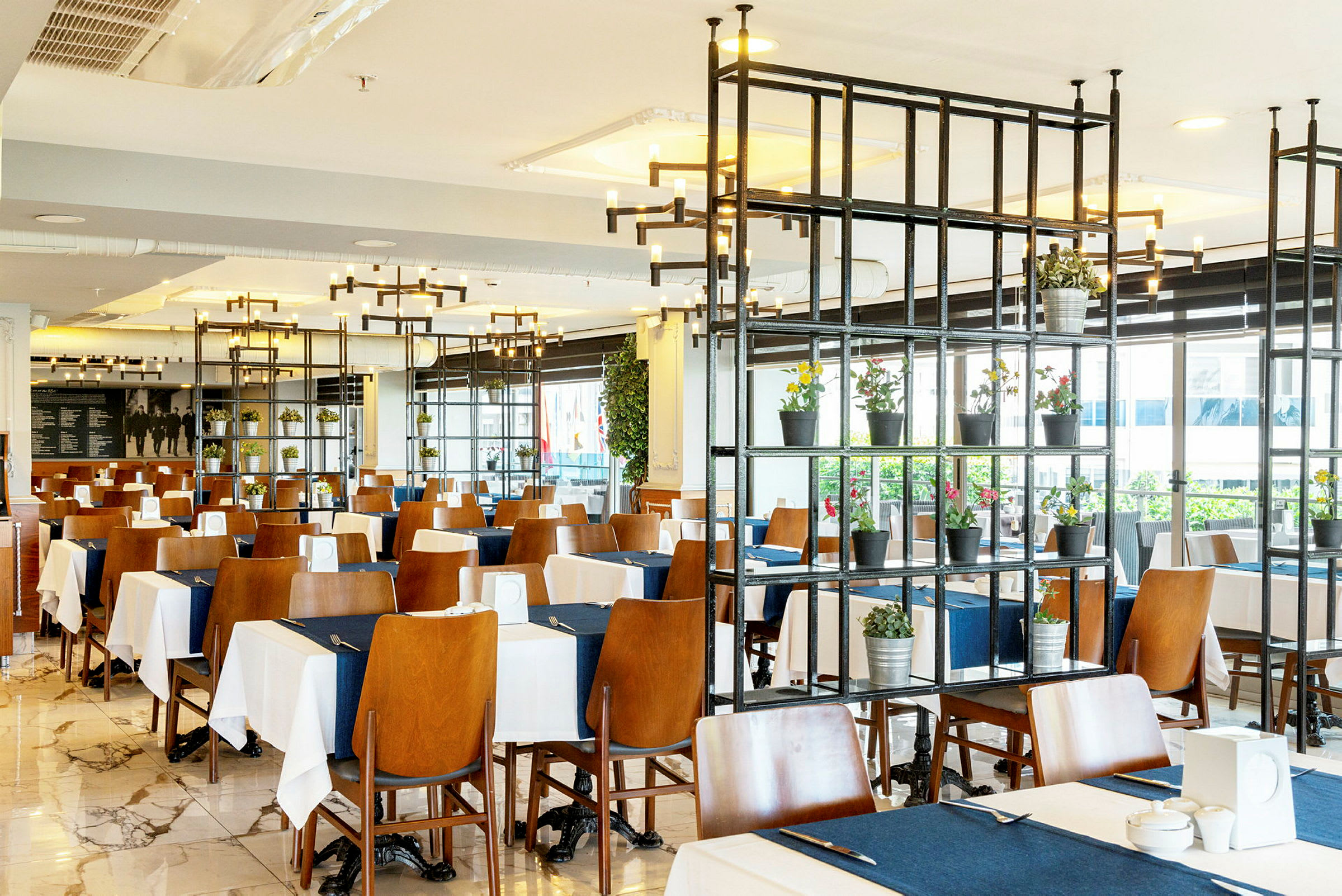 Restaurant med borde dækket med hvide og blå duge. (AI-genereret tekst)