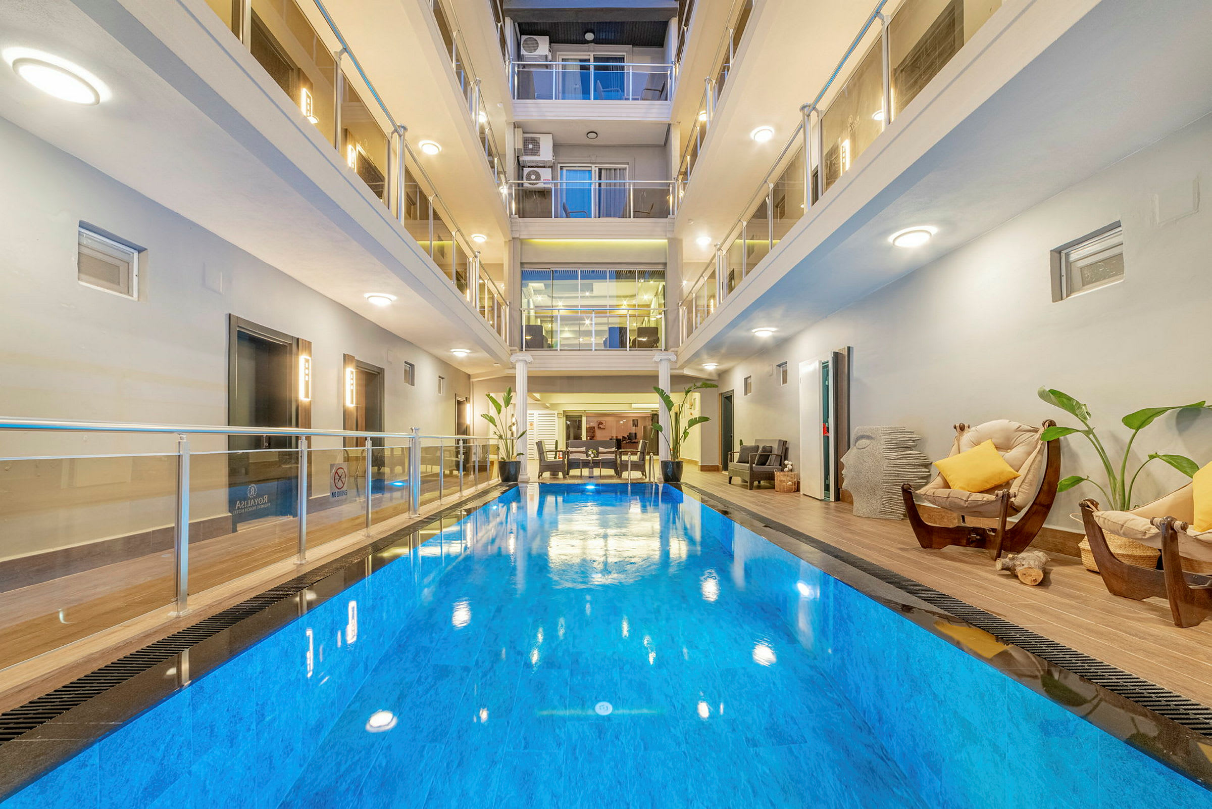 Indendørs swimmingpool på et moderne hotel med omkringliggende siddepladser. (AI-genereret tekst)